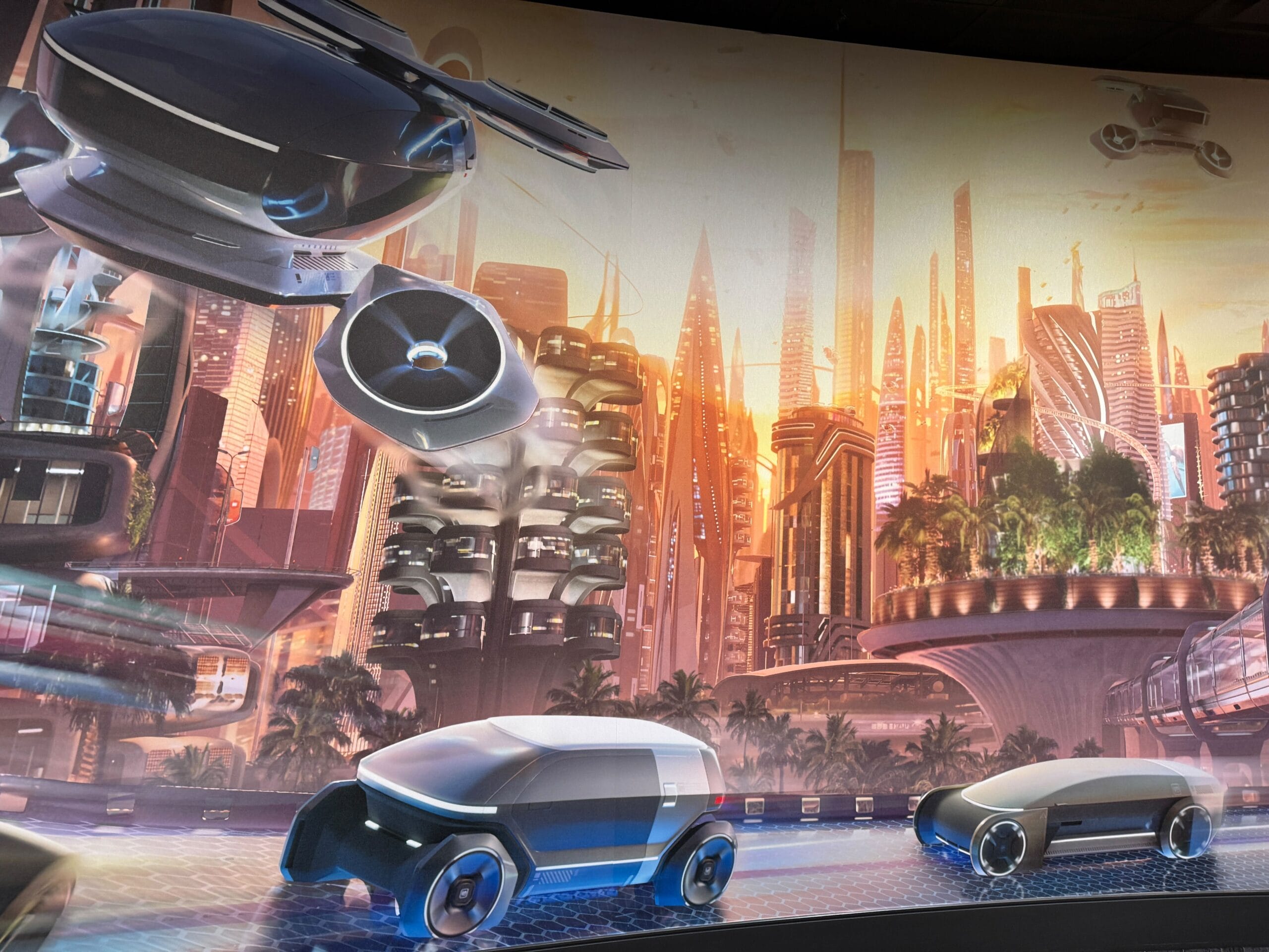Futuristic cityscape with flying drones and sleek, autonomous vehicles on a Test Track against a sunset sky.