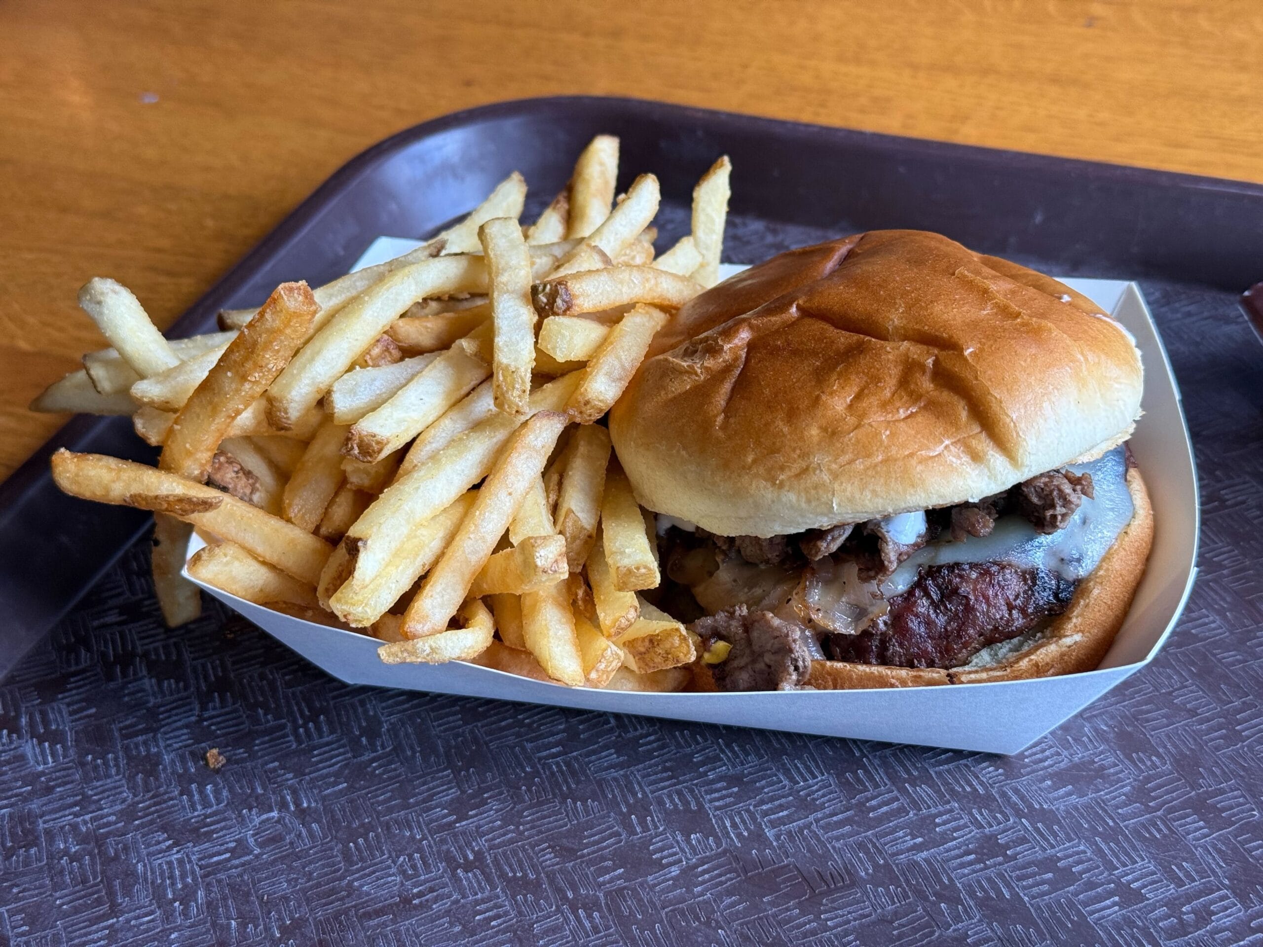 A tray with a cheeseburger in a bun and crispy fries from Disney's Port Orleans Resort.