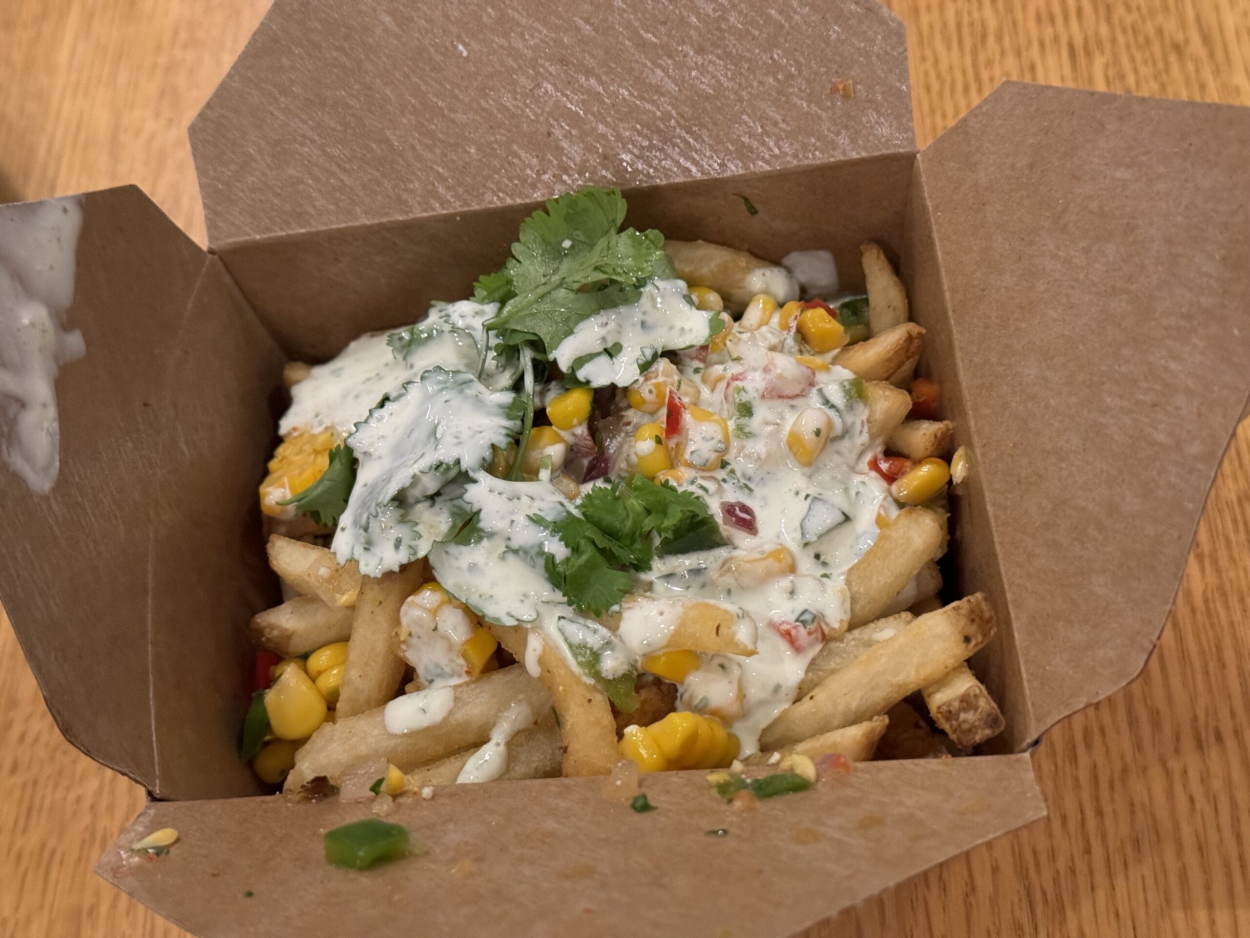 French fries topped with corn, veggies, and creamy sauce, just like at Riverside Mill in Disney Port Orleans Resort.