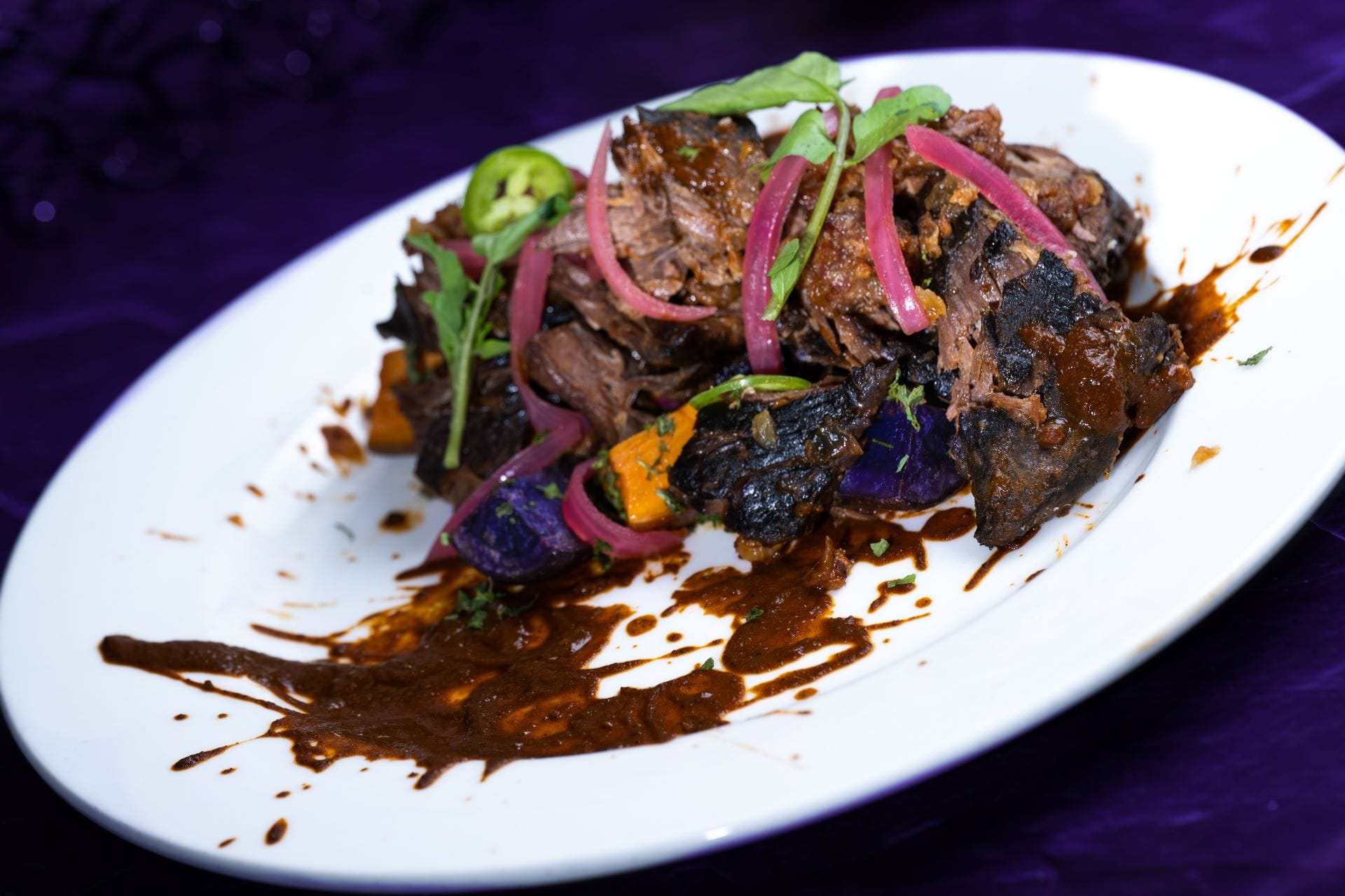 Shredded beef with sauce, pickled onions, and greens—a festive food and beverage at Mickey's Not So Scary Halloween Party 2025.