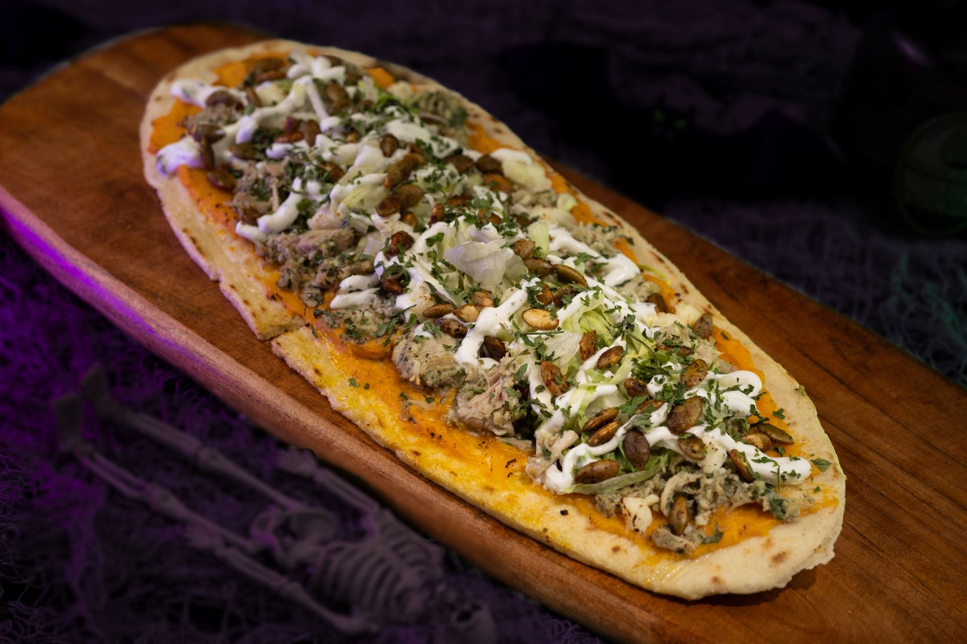 Flatbread topped with shredded meat, herbs, and cheese—a tasty food and beverage for Mickey's Not So Scary Halloween Party 2025.