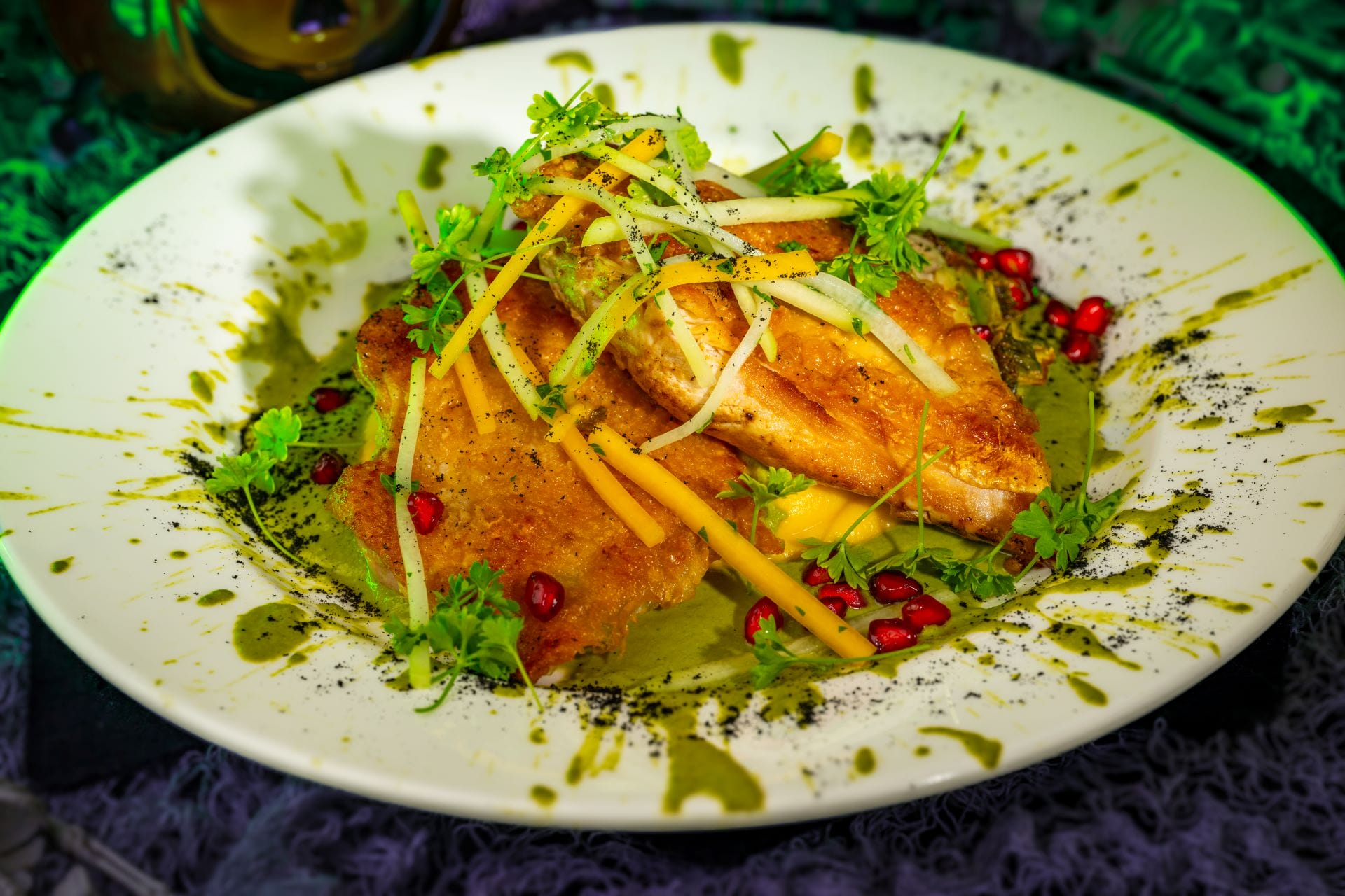 Pan-seared fish fillets with julienned vegetables and herbs, a 2025 food and beverages highlight on green sauce.