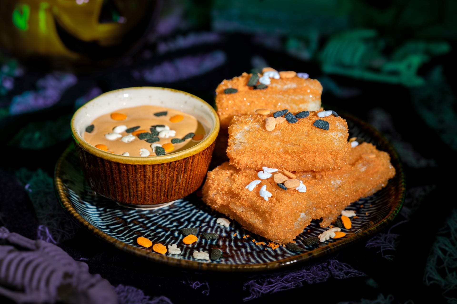 A plate of churros with orange sugar and Halloween sprinkles, served at Mickey's Not So Scary Halloween Party 2025.