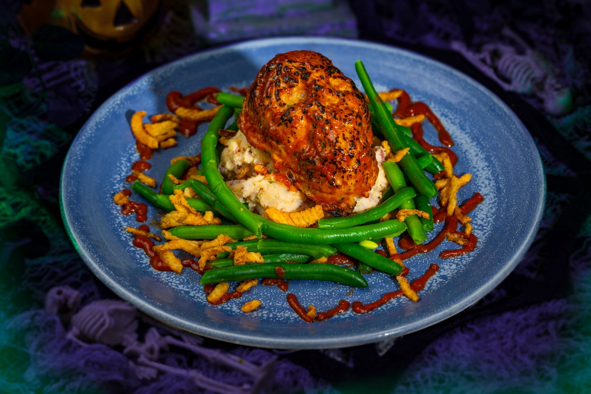 Stuffed chicken breast on mashed potatoes with green beans and crispy onions, perfect food for Mickey's Not So Scary Halloween Party.