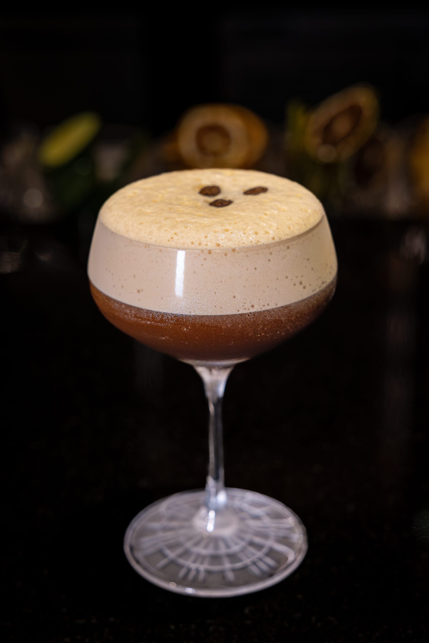 A creamy espresso martini at Bourbon Steak, topped with coffee beans, sits elegantly at Walt Disney World Dolphin Hotel.