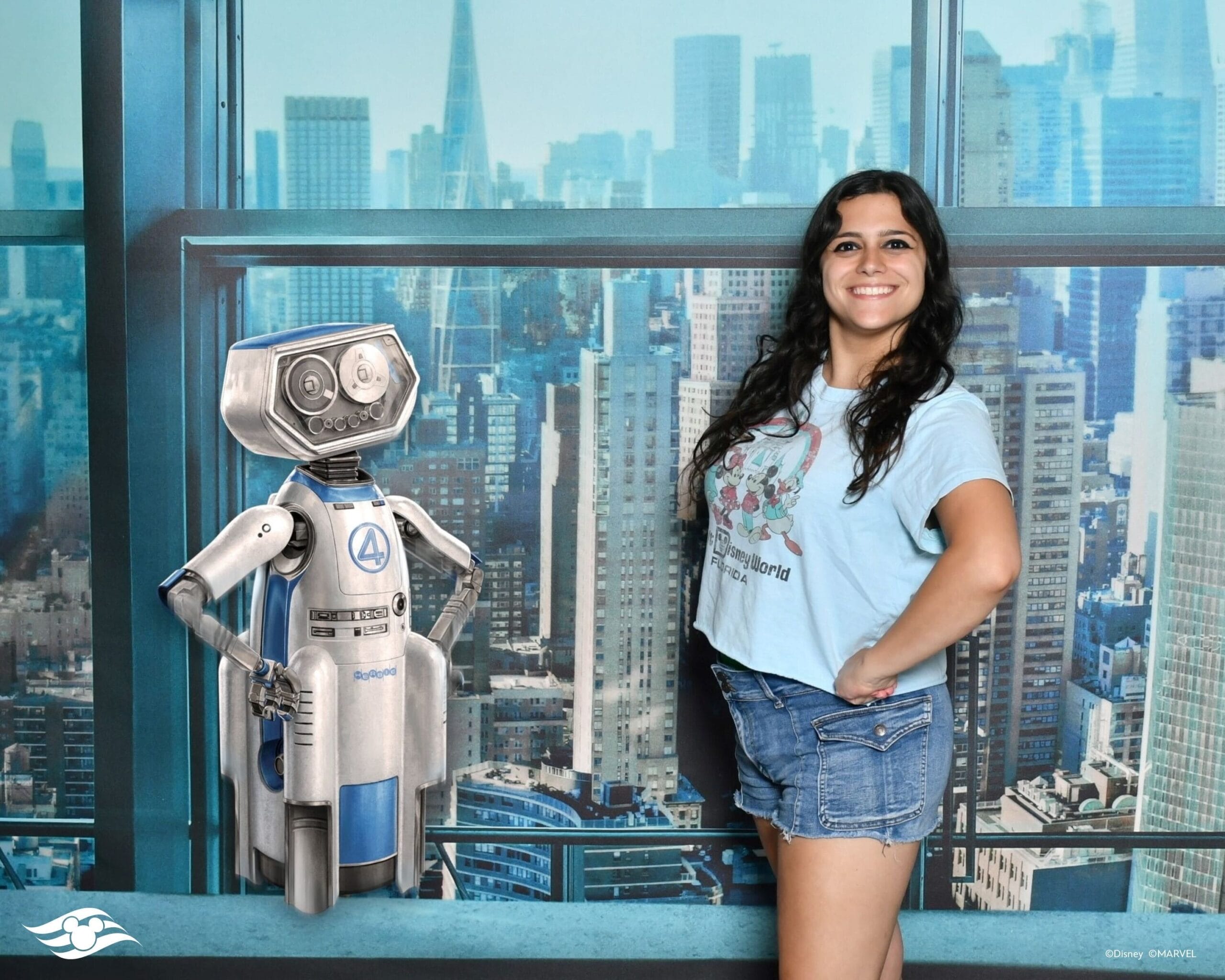 A woman smiles and poses for a Magic Shot with HERBIE, city skyline shining behind them.