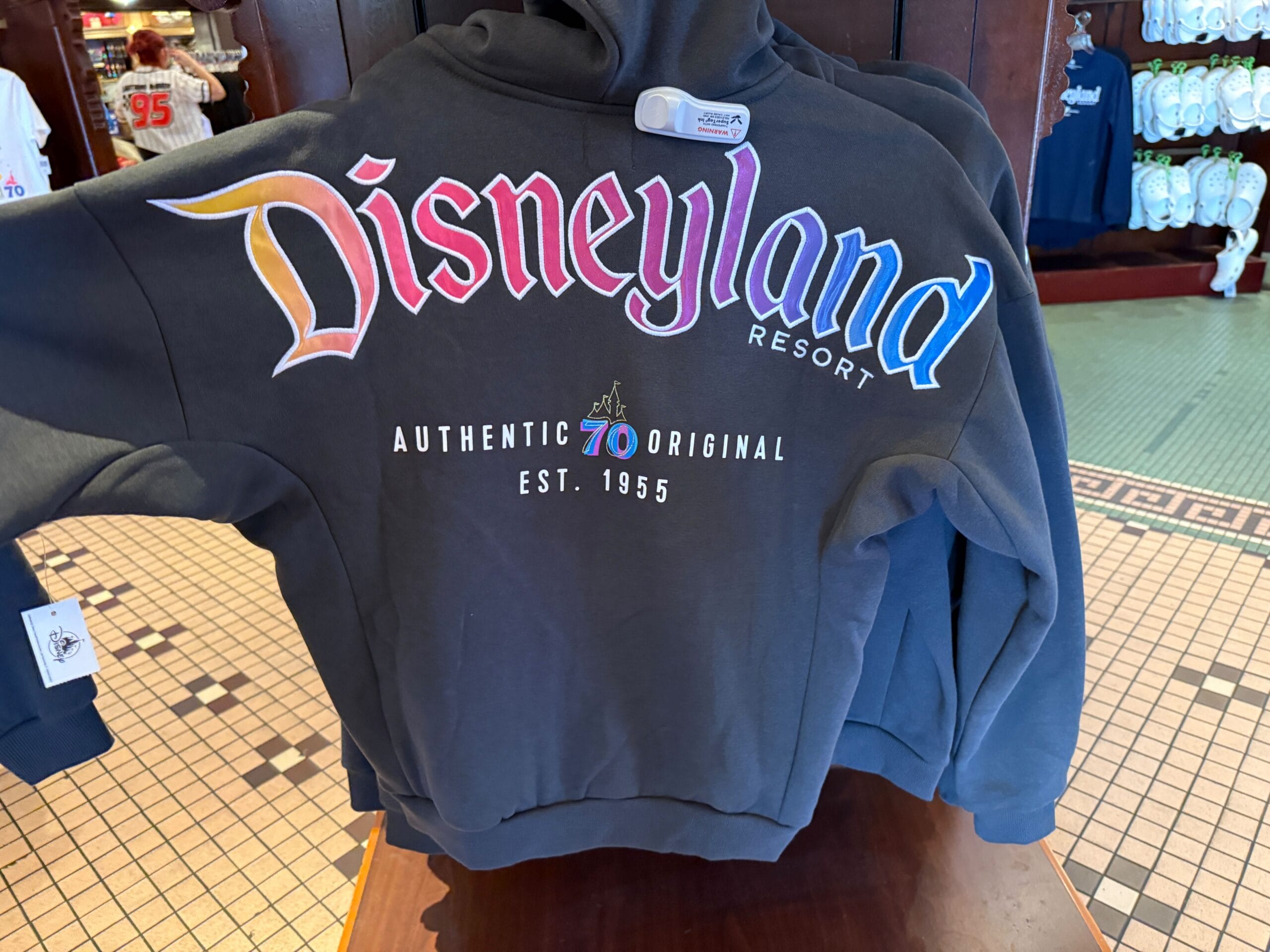 Black Disneyland Resort hoodie, part of the happy collection, celebrates "70th Authentic Original Est. 1955" in-store.
