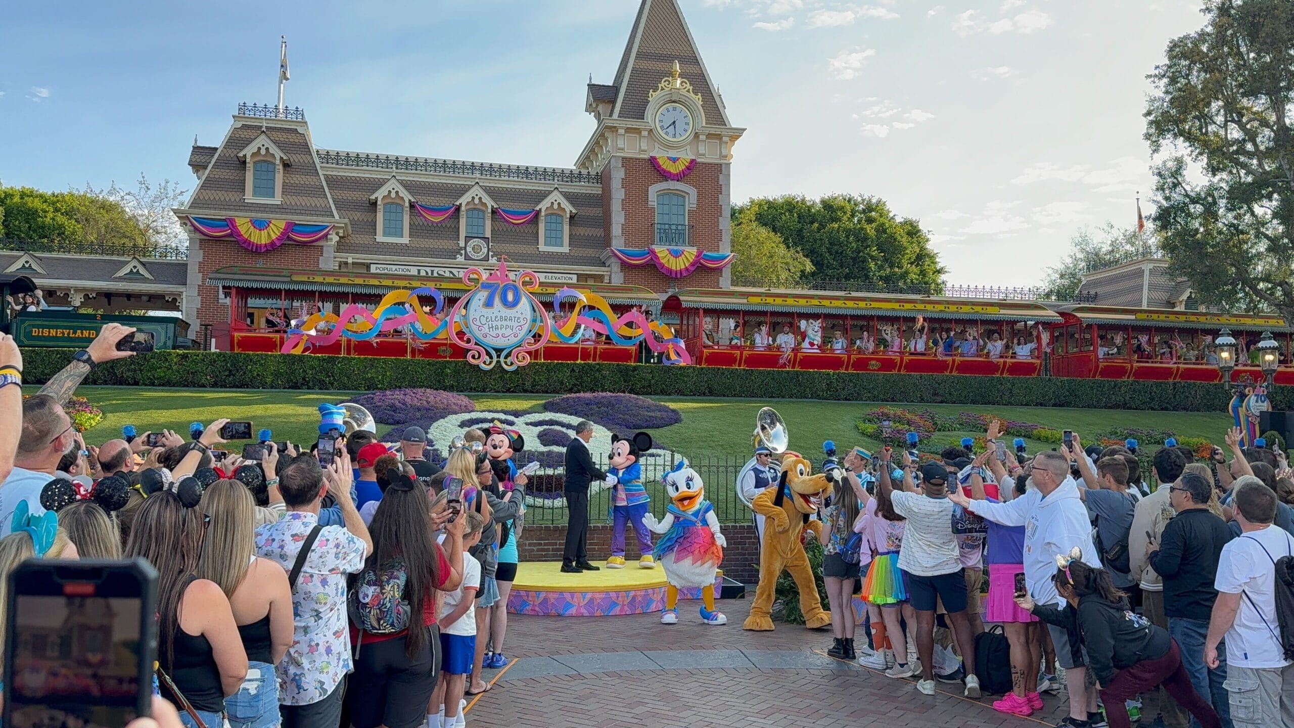 Disney characters perform at Disneyland’s train station as crowds celebrate the Disneyland 70th Anniversary.