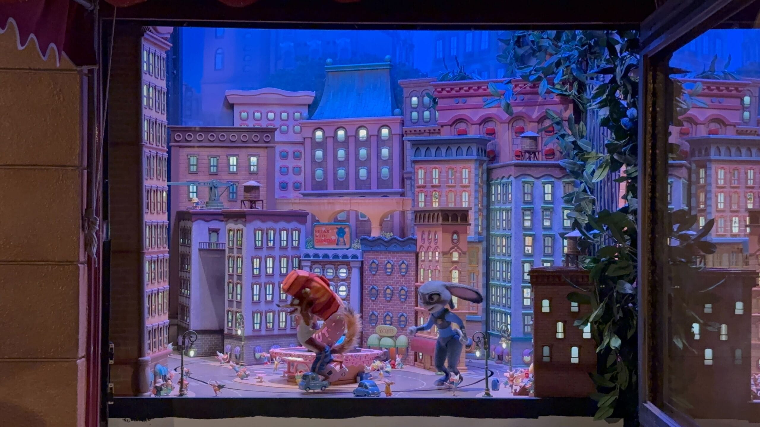 A colorful Main Street Window Display featuring animated Zootopia mice and tall buildings in a whimsical scene.