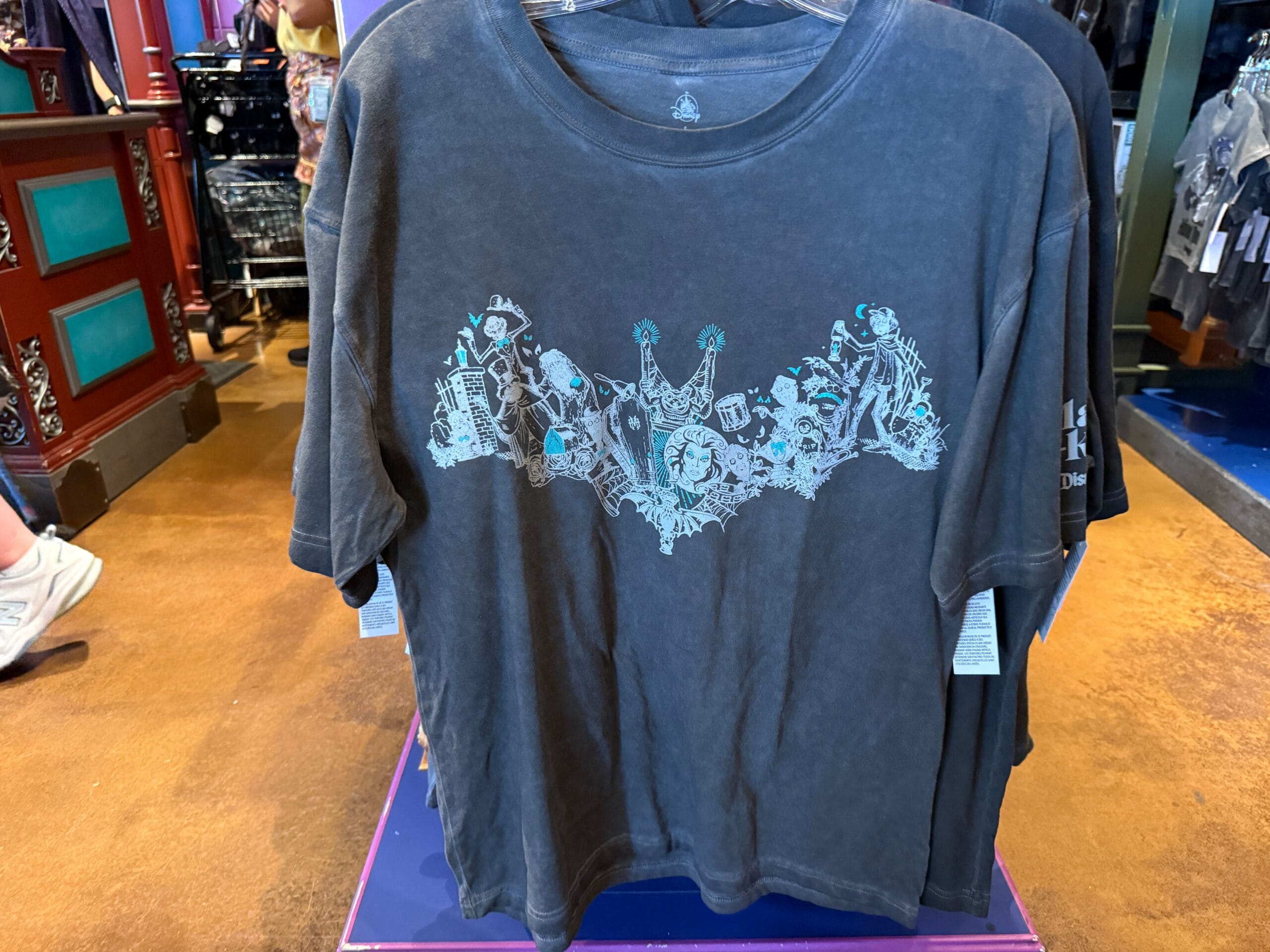 Gray T-shirt with a teal and white Haunted Mansion design—perfect for Disneyland fans and HM Merchandise collectors.