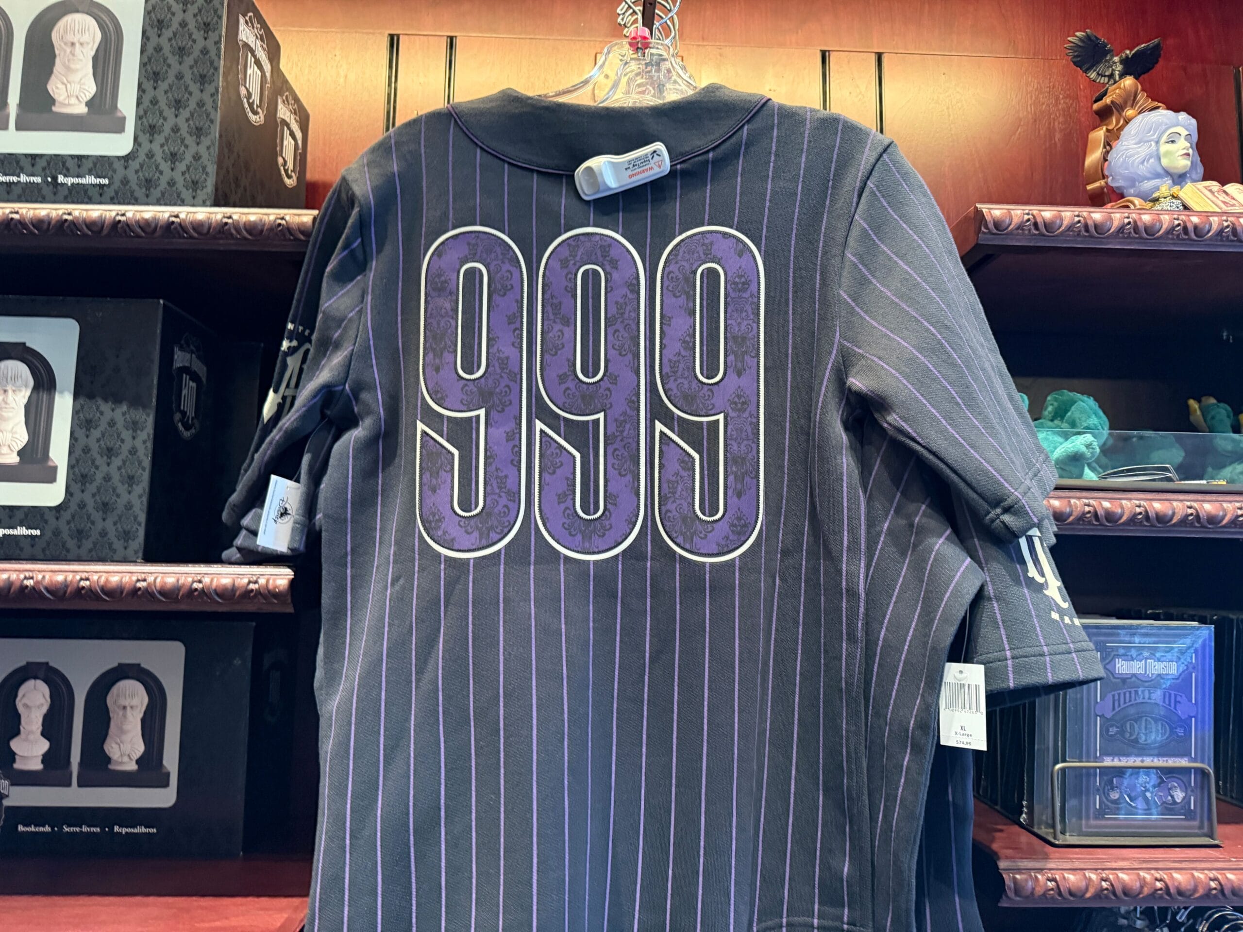 Black shirt with purple "999" on the back, displayed among HM Merchandise at a Disneyland store.