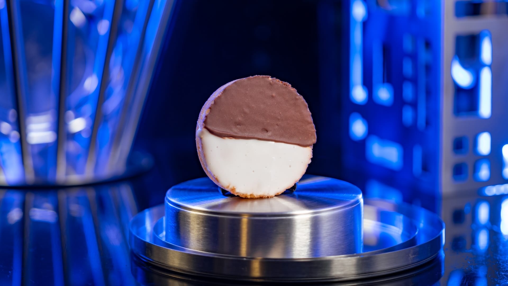 A half-chocolate, half-vanilla cookie on a shiny stand shines like a Fantastic Four treat at Disney Parks.