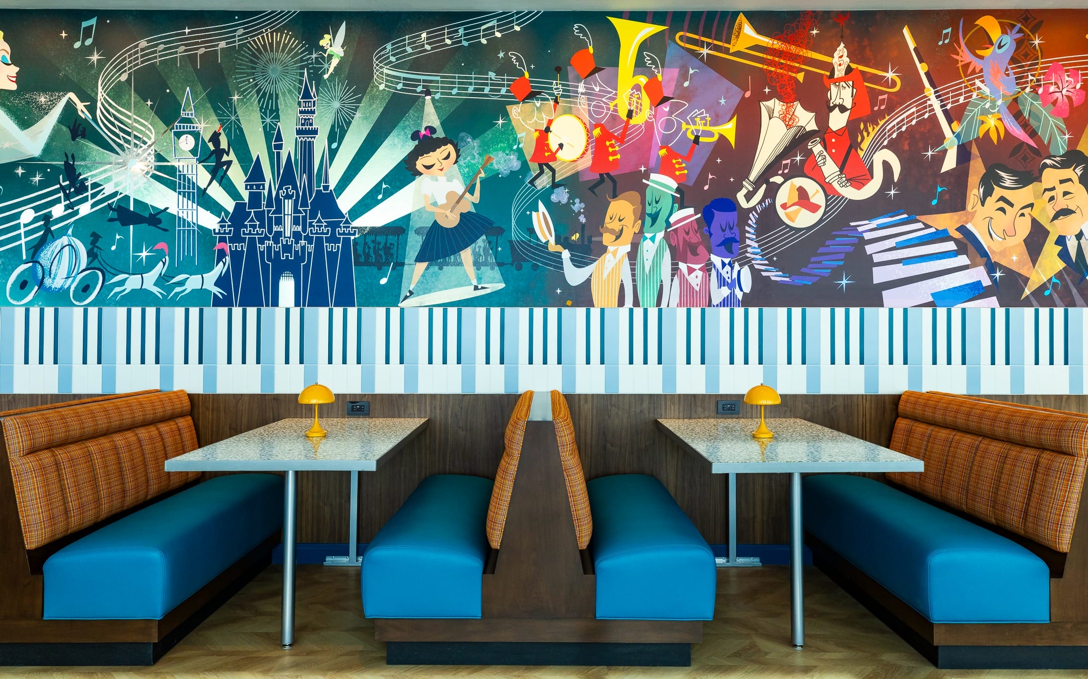 Colorful mural of musicians and notes above blue booths in the retro-style High Key Club at the Disneyland Hotel.