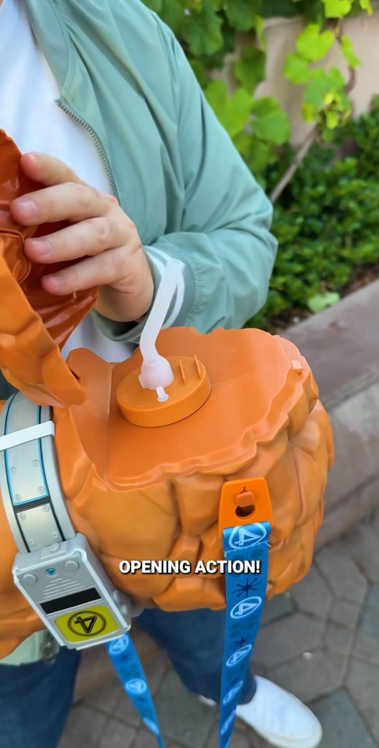 Person opens rock-like toy with blue lanyard and digital device; Fantastic Four "OPENING ACTION!" text displayed.