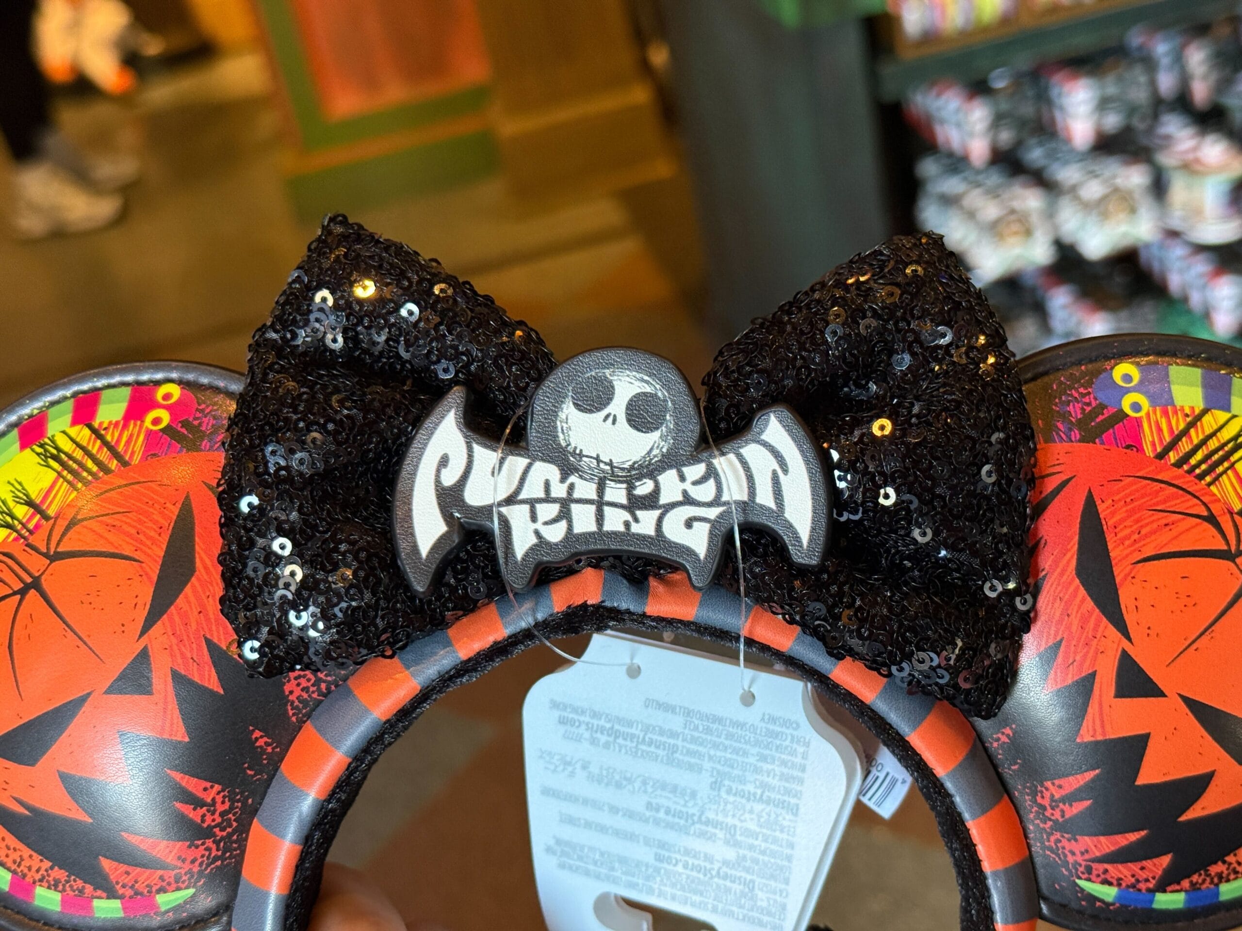 A headband with black sequin bow, "Pumpkin King" text, and orange pumpkin designs on the ears.