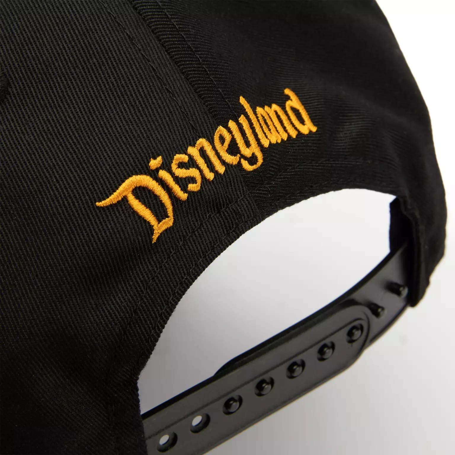 Close-up of the back of a black cap from the Disney Store Halloween collection, "Disneyland" embroidered above the strap.