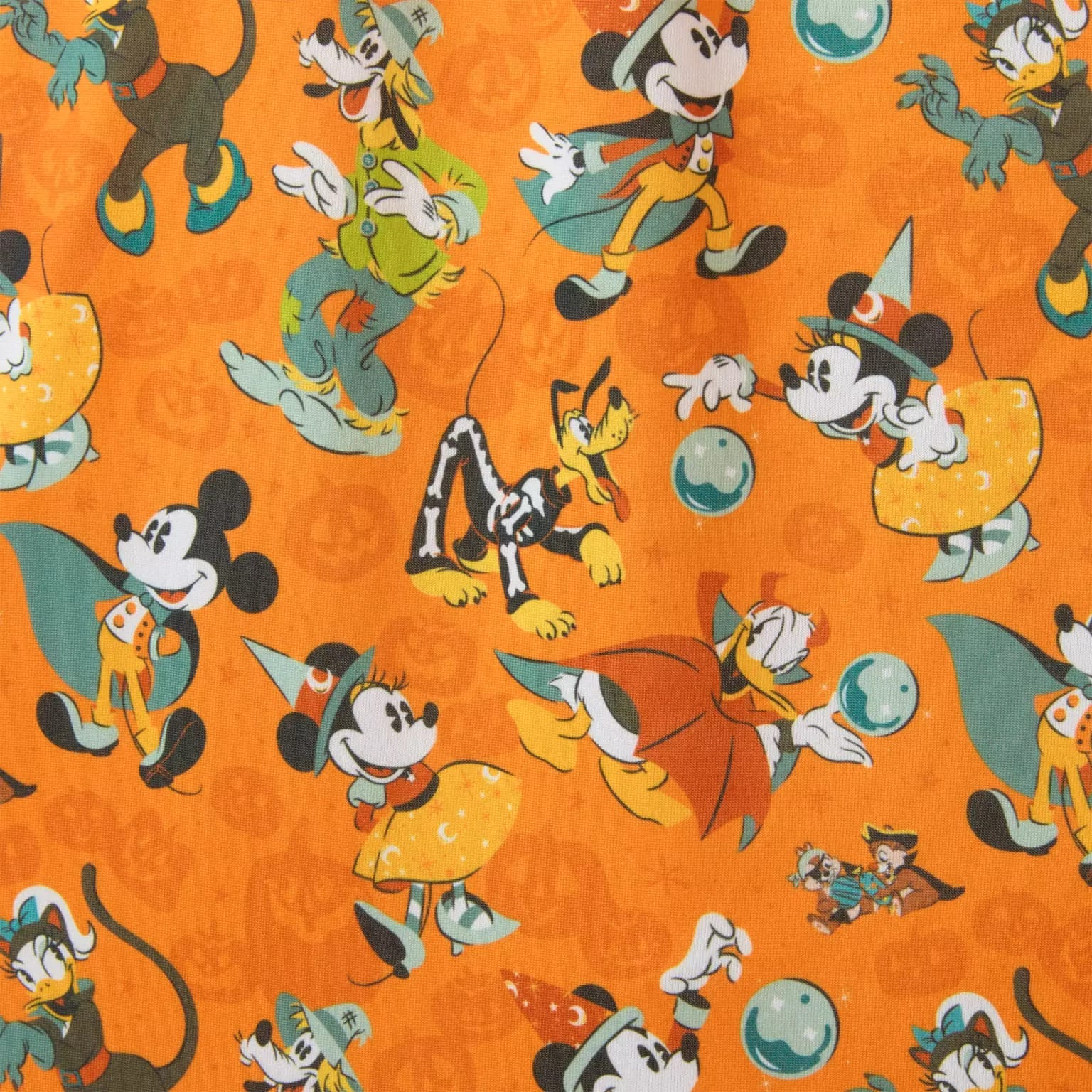Disney characters in Halloween costumes on an orange background, inspired by new Disney Halloween merchandise.