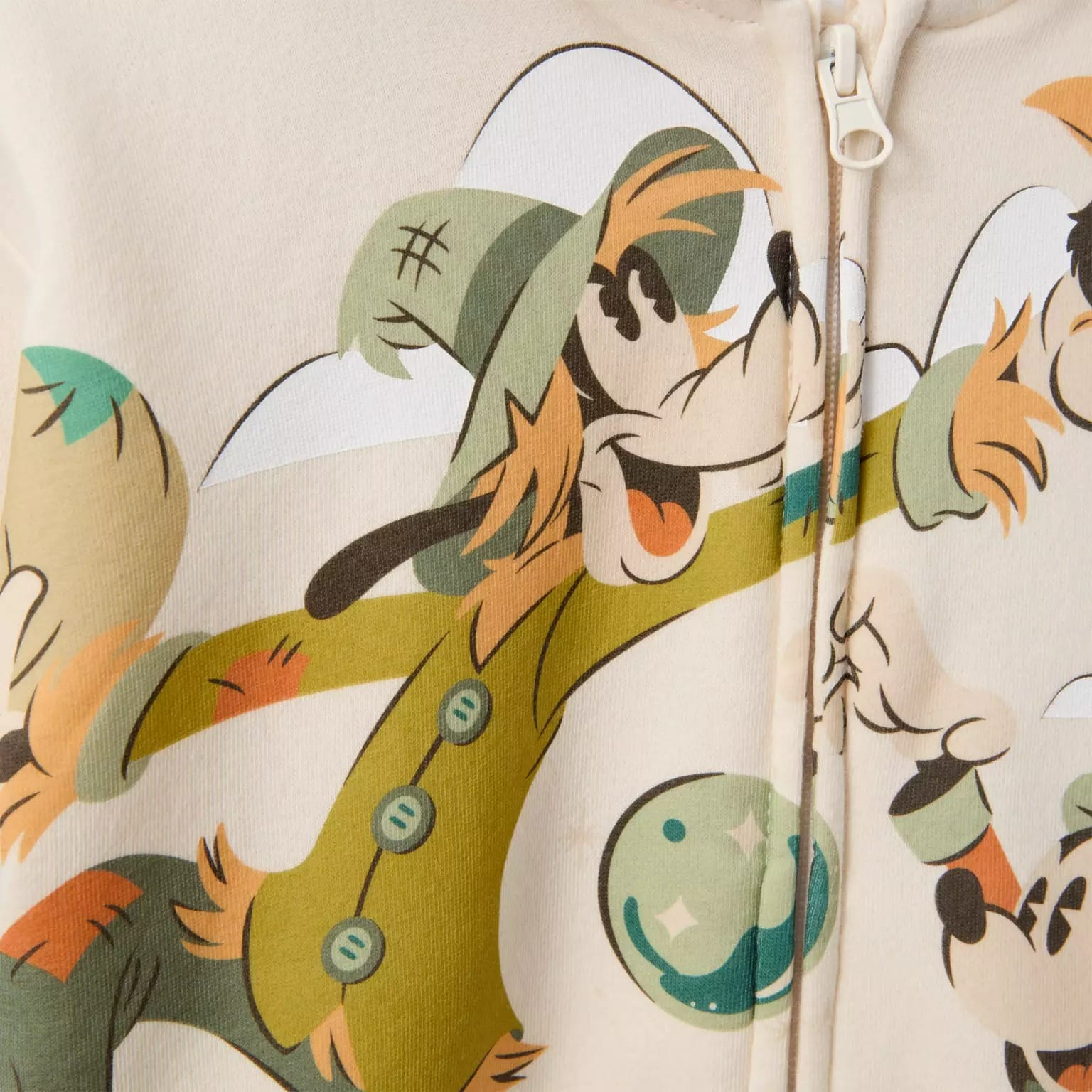 Cartoon dog in a green outfit and hat, smiling on a zippered fabric—a fun new Disney Store Halloween merchandise find.