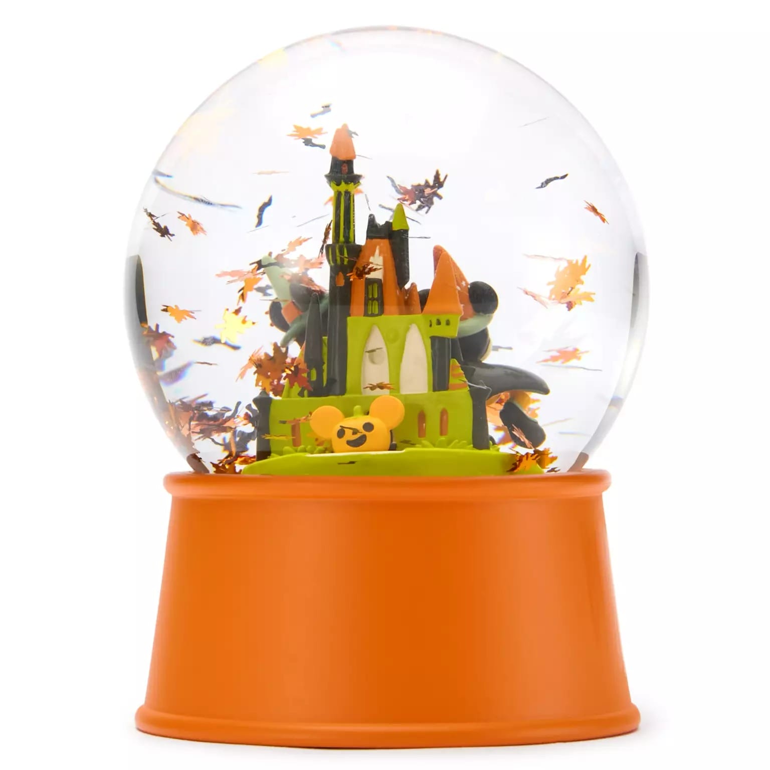 A Disney Store Halloween snow globe with a haunted house, bats, and an orange Mickey Mouse face on an orange base.