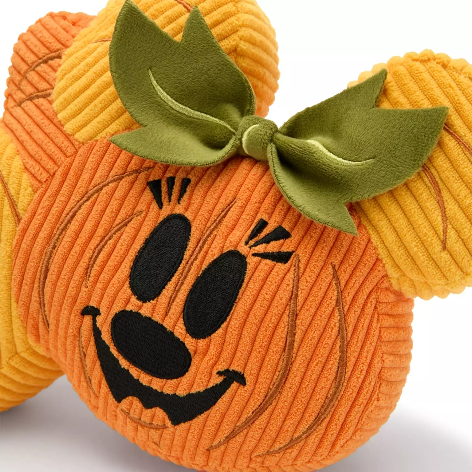 Plush pumpkin with embroidered face, green bow, and stem ears—part of new Disney Store Halloween merchandise.