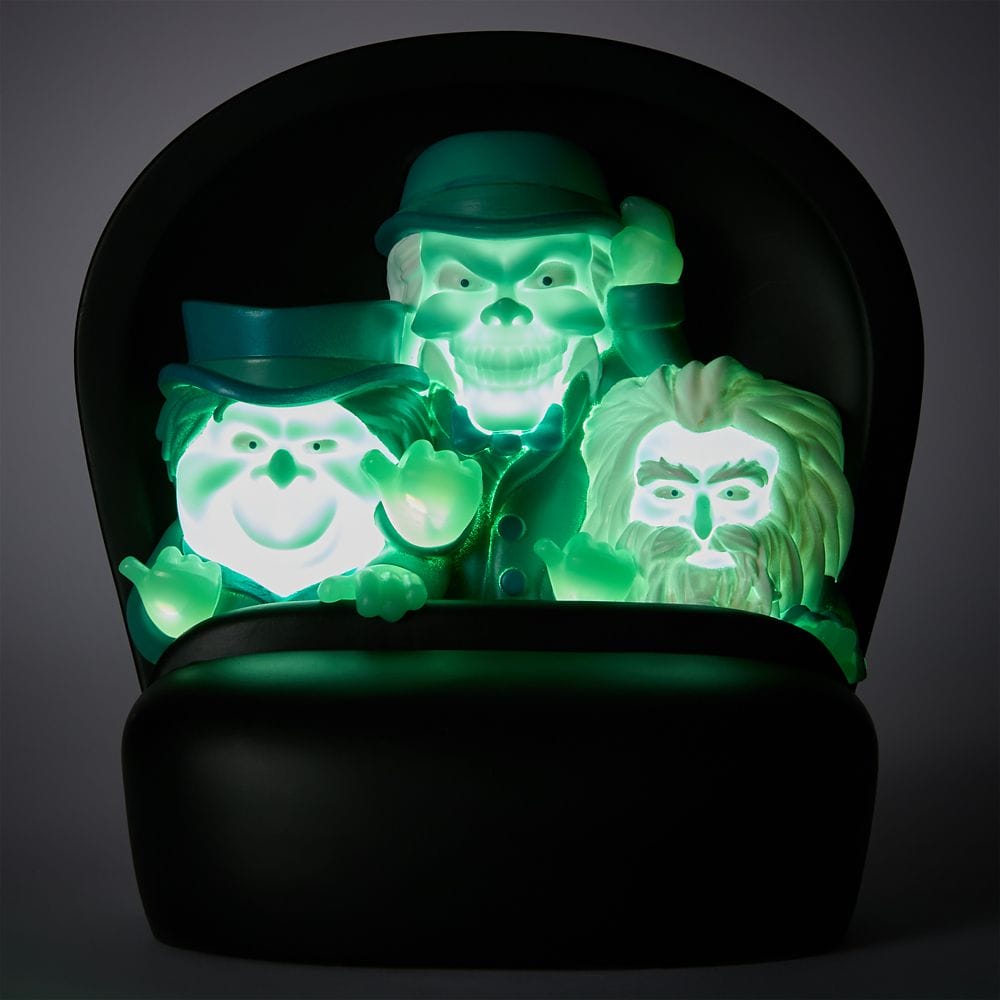 Three glowing green ghost figurines with hats and beards sit together from the Haunted Mansion Collection.