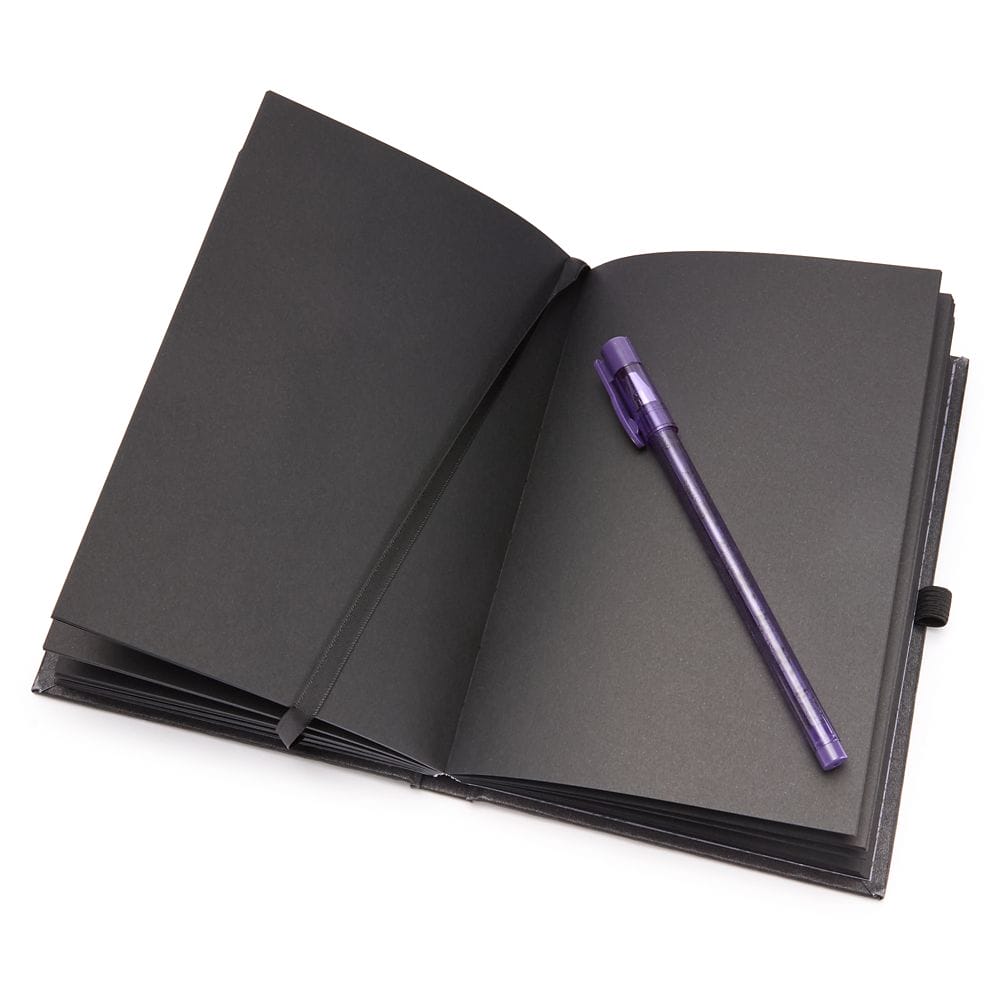 Open notebook with black pages and a purple pen, inspired by the Haunted Mansion Collection, on a white background.