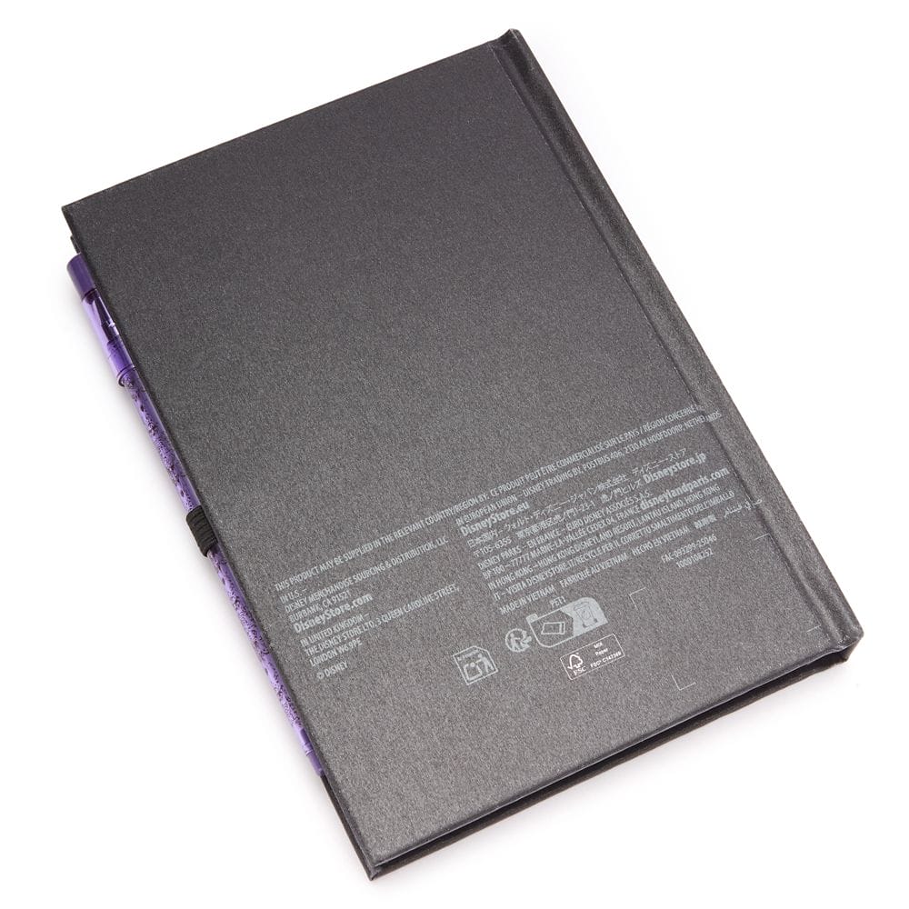 A closed black notebook from the Haunted Mansion Collection with text, symbols, and a purple pen attached to its side.
