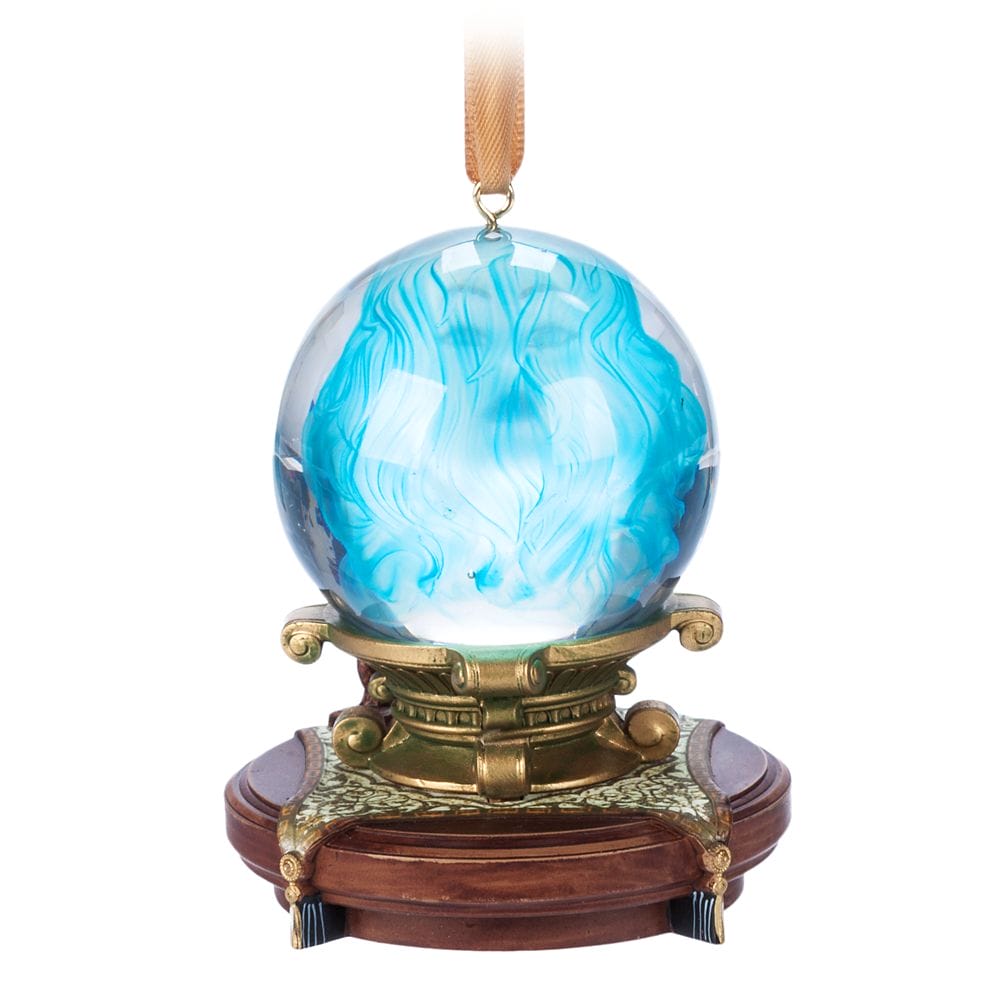 A glass orb with swirling blue patterns sits on an ornate gold and wood stand from the Haunted Mansion Collection.