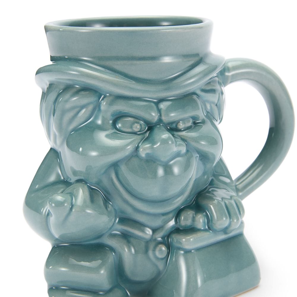 A teal ceramic mug from the Haunted Mansion Collection, shaped like a grinning character wearing a hat and holding a cane.