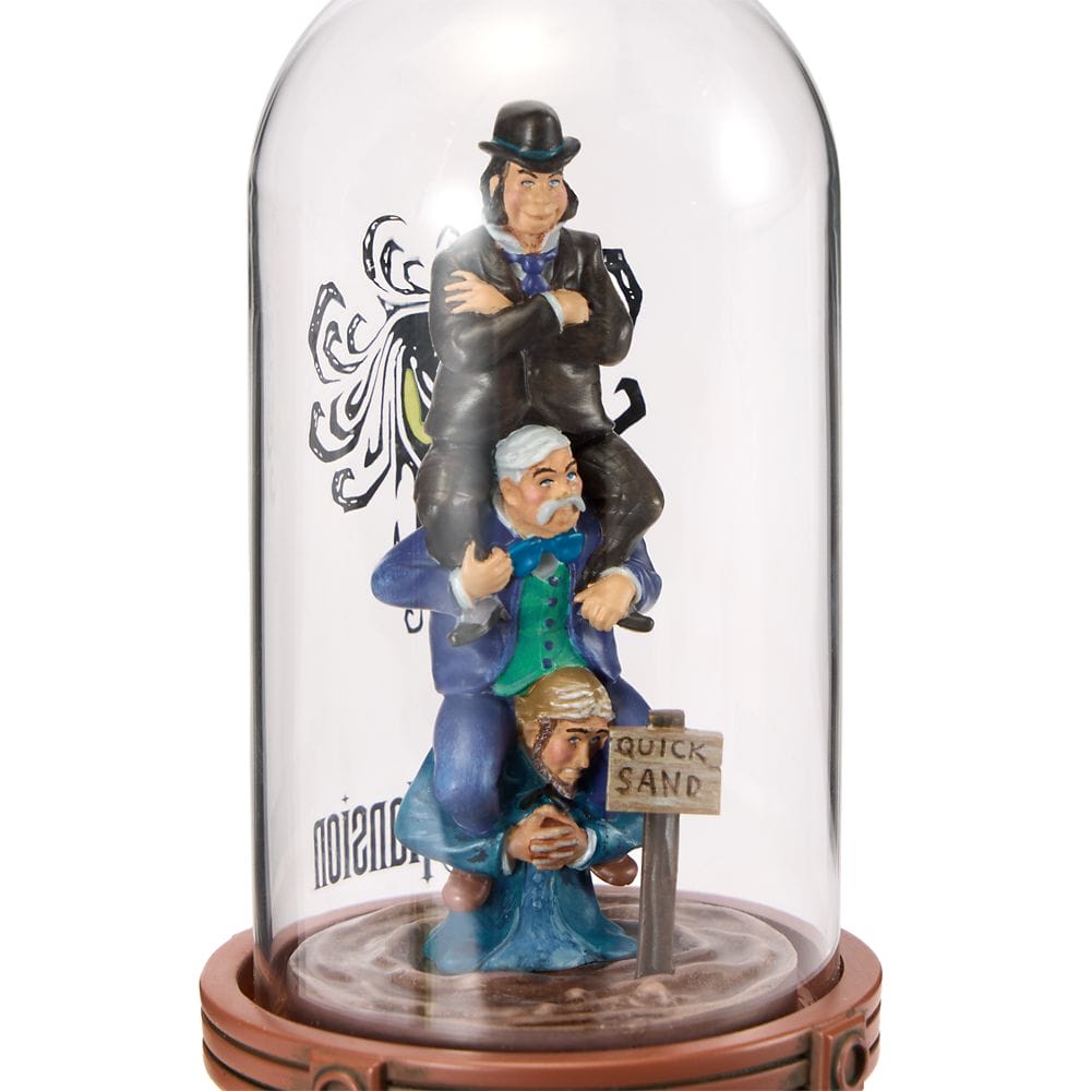 Three figurines stacked under a glass dome; part of the Haunted Mansion Collection, with a "QUICKSAND" sign.