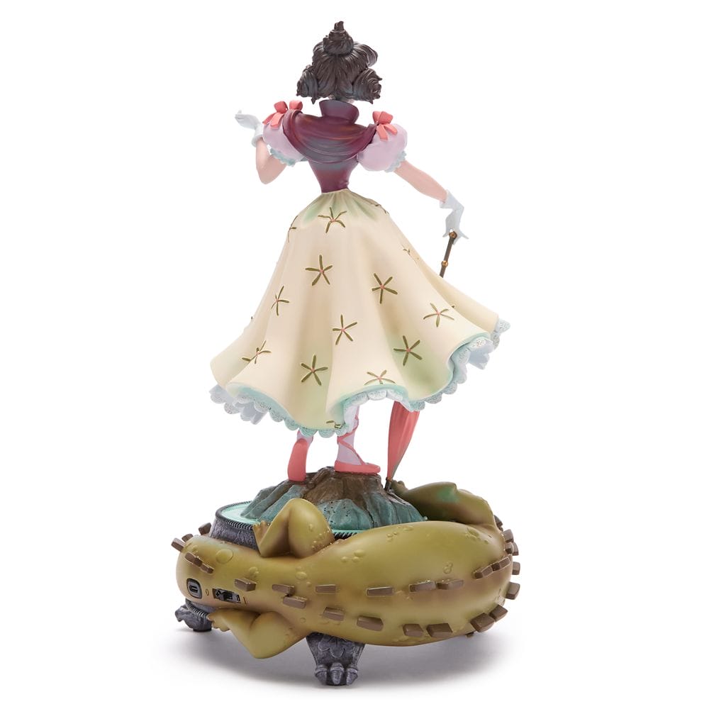 A Disney Store figurine of a woman in a yellow star dress stands with a brown creature, inspired by the Haunted Mansion.