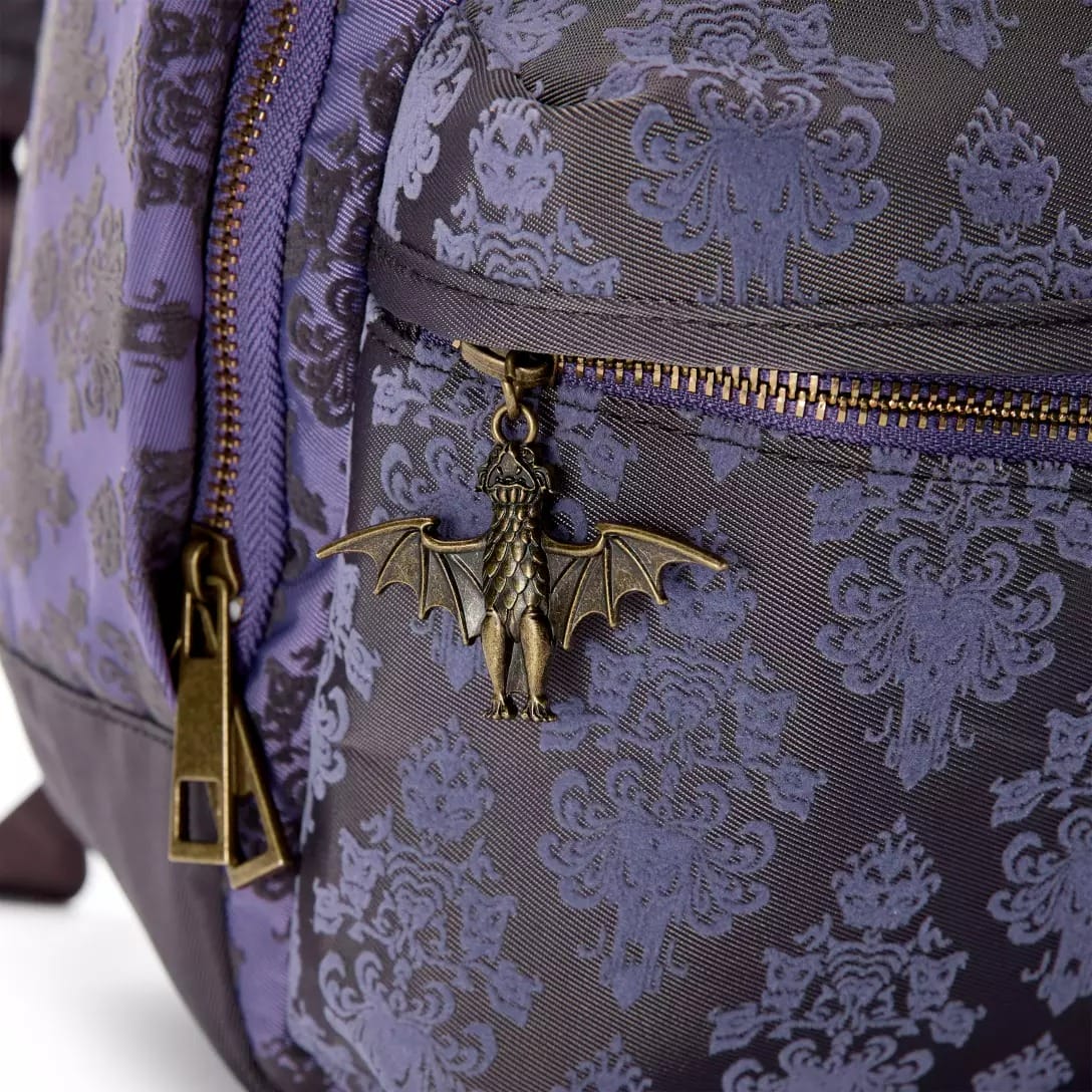 Close-up of a bat-shaped zipper pull on a purple and gray backpack from the Haunted Mansion Collection.