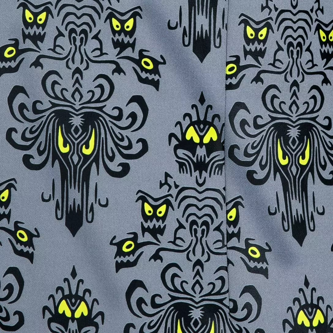 Gray fabric with black ghostly faces and yellow eyes, inspired by the Haunted Mansion Collection at Disney Store.
