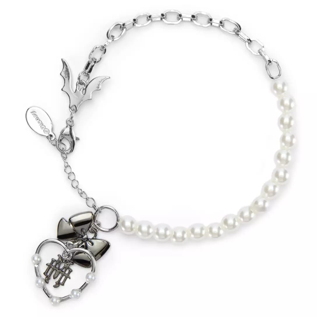 Silver chain and pearl necklace from the Haunted Mansion Collection, with bat charm, black bow, and heart pendant.