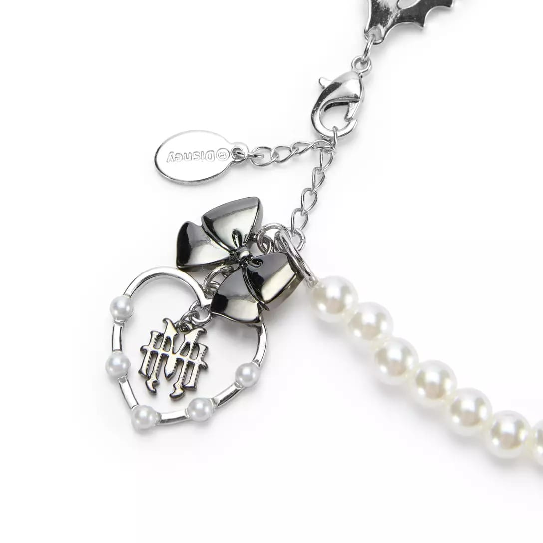 Silver heart and bow charms with faux pearls on a chain, inspired by the Haunted Mansion Collection and a MONSTER HIGH logo.