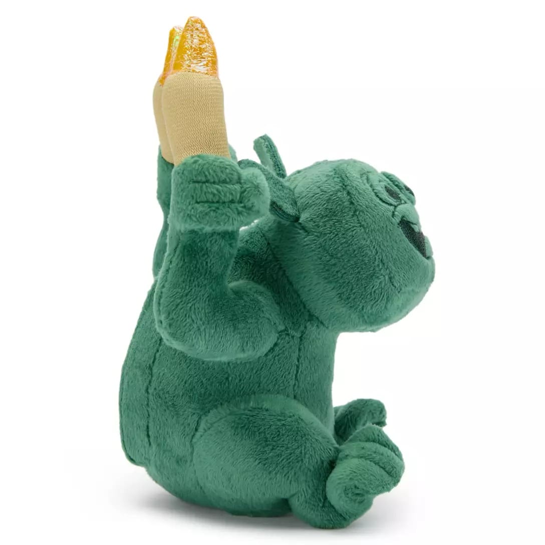 Green plush toy gorilla from the Disney Store sits upright holding a yellow banana, part of the Haunted Mansion Collection.