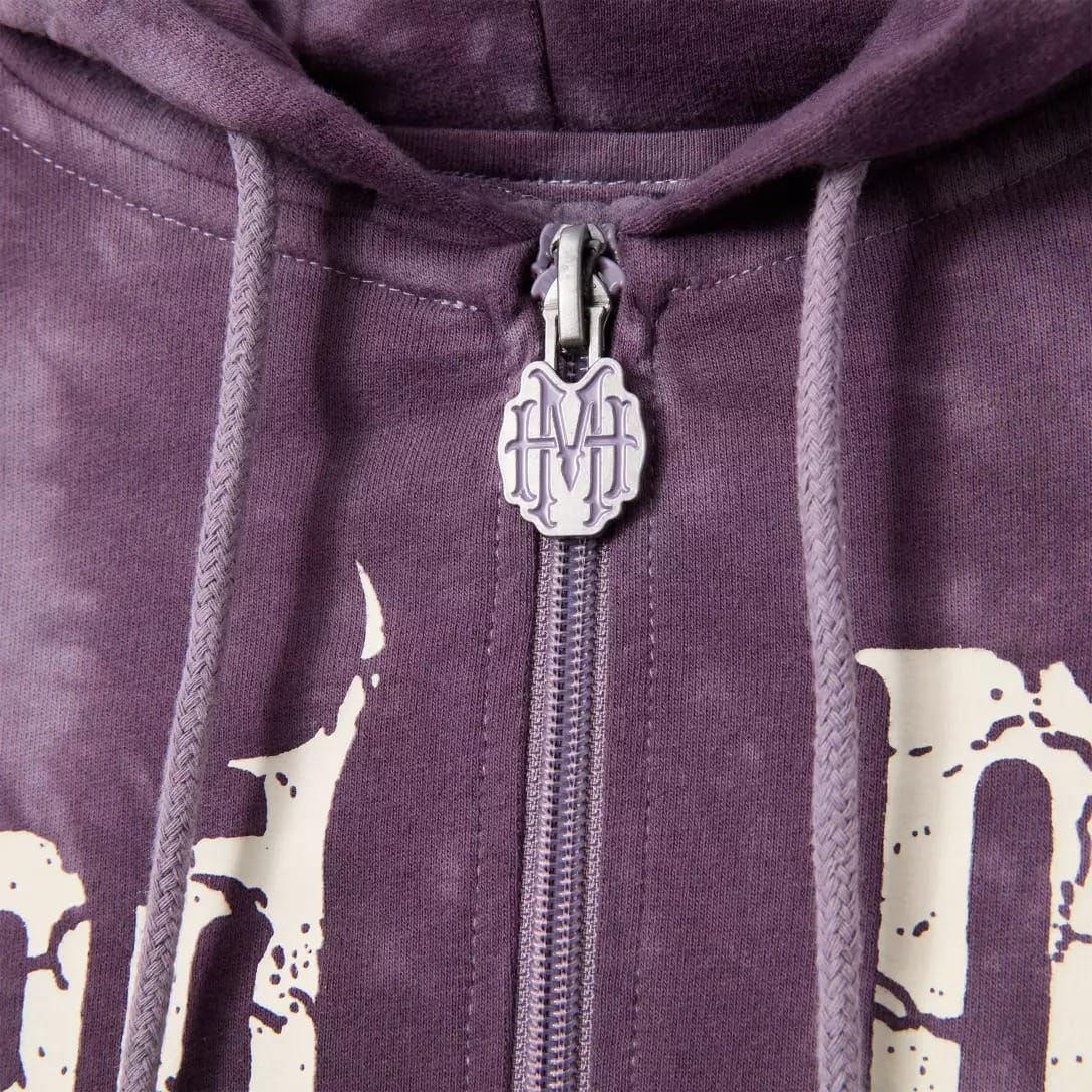 Close-up of a purple Haunted Mansion hoodie with zipper and HM logo pull, available at the Disney Store.