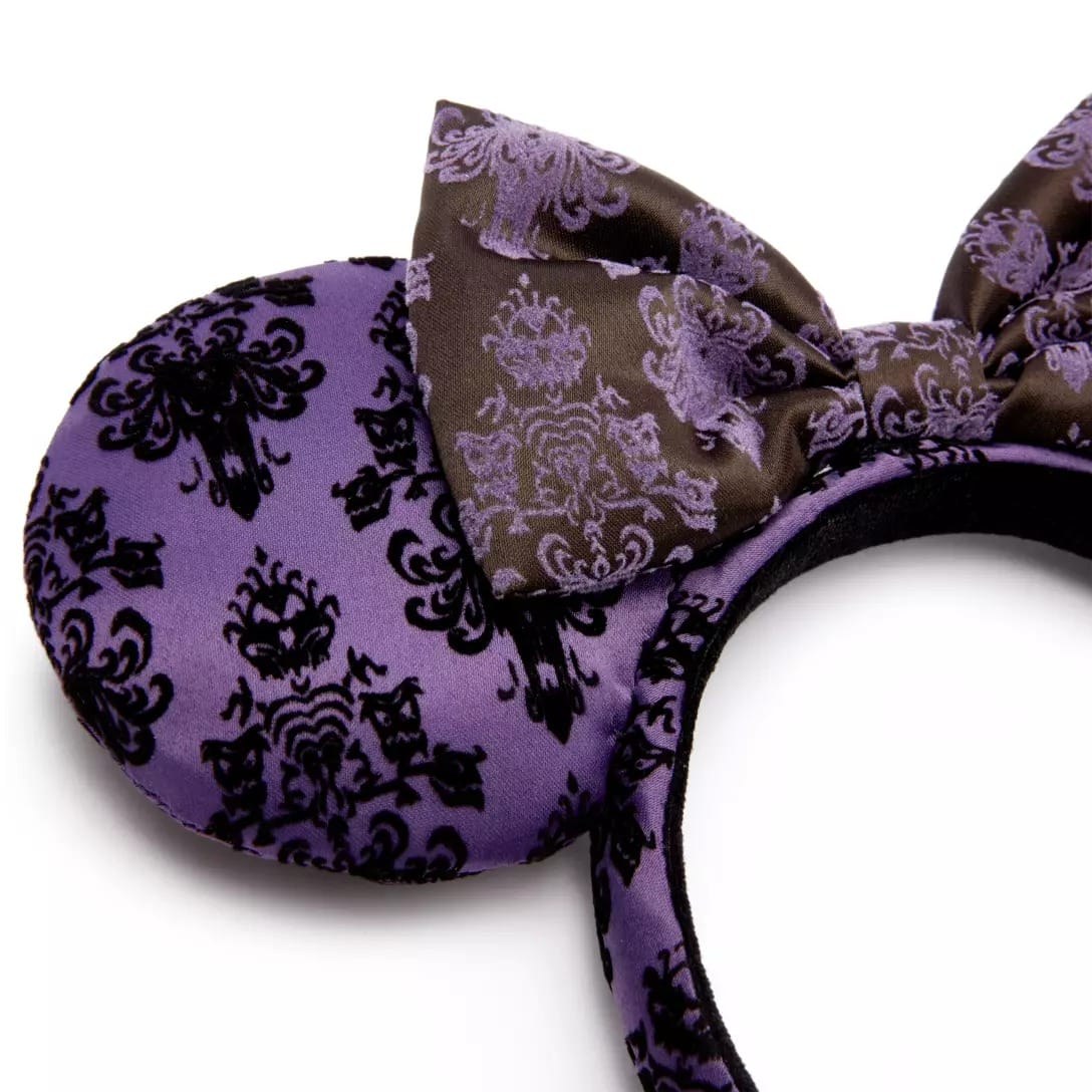 Purple Minnie Mouse ear headband from the Haunted Mansion Collection, featuring a black damask pattern and brown bow.