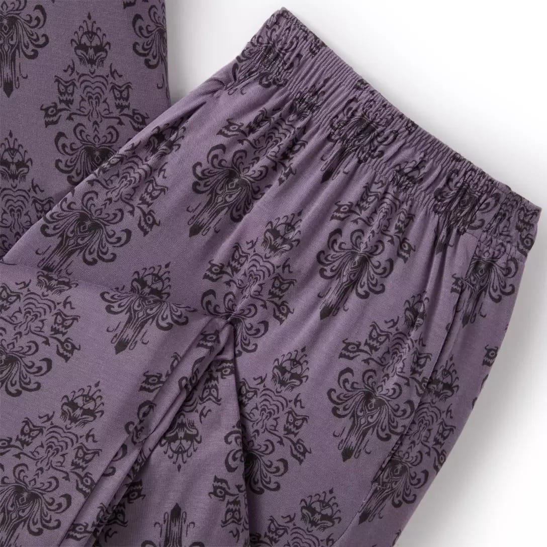 Close-up of purple pants from the Haunted Mansion Collection with black ornate floral pattern and elastic waistband.