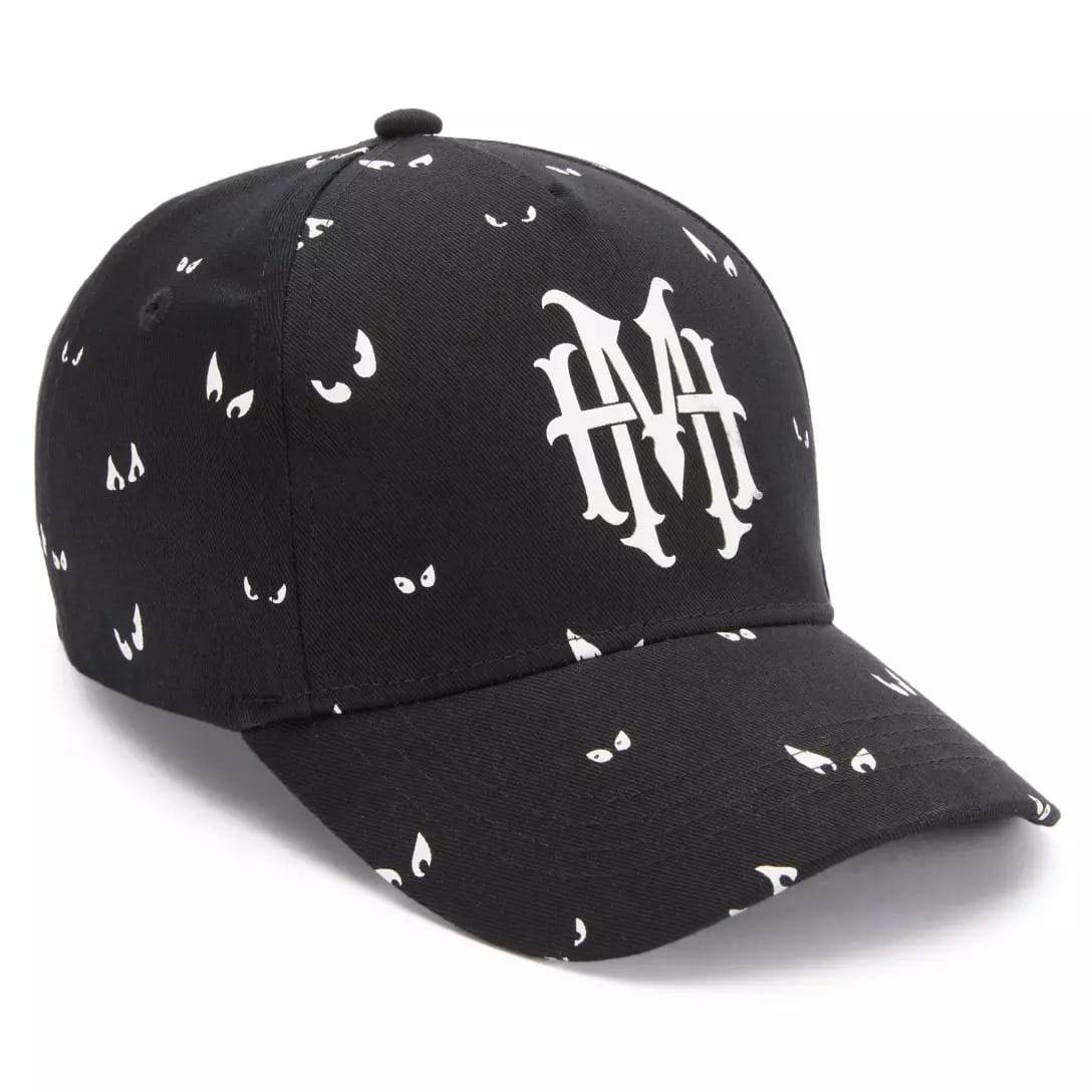 Black baseball cap with white eye patterns and a bold "MM" logo, inspired by the Haunted Mansion Collection.