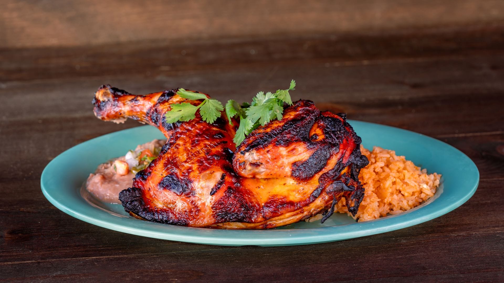 Grilled chicken garnished with cilantro, from the 2025 Plaza de la Familia menu at Disney California Adventure.