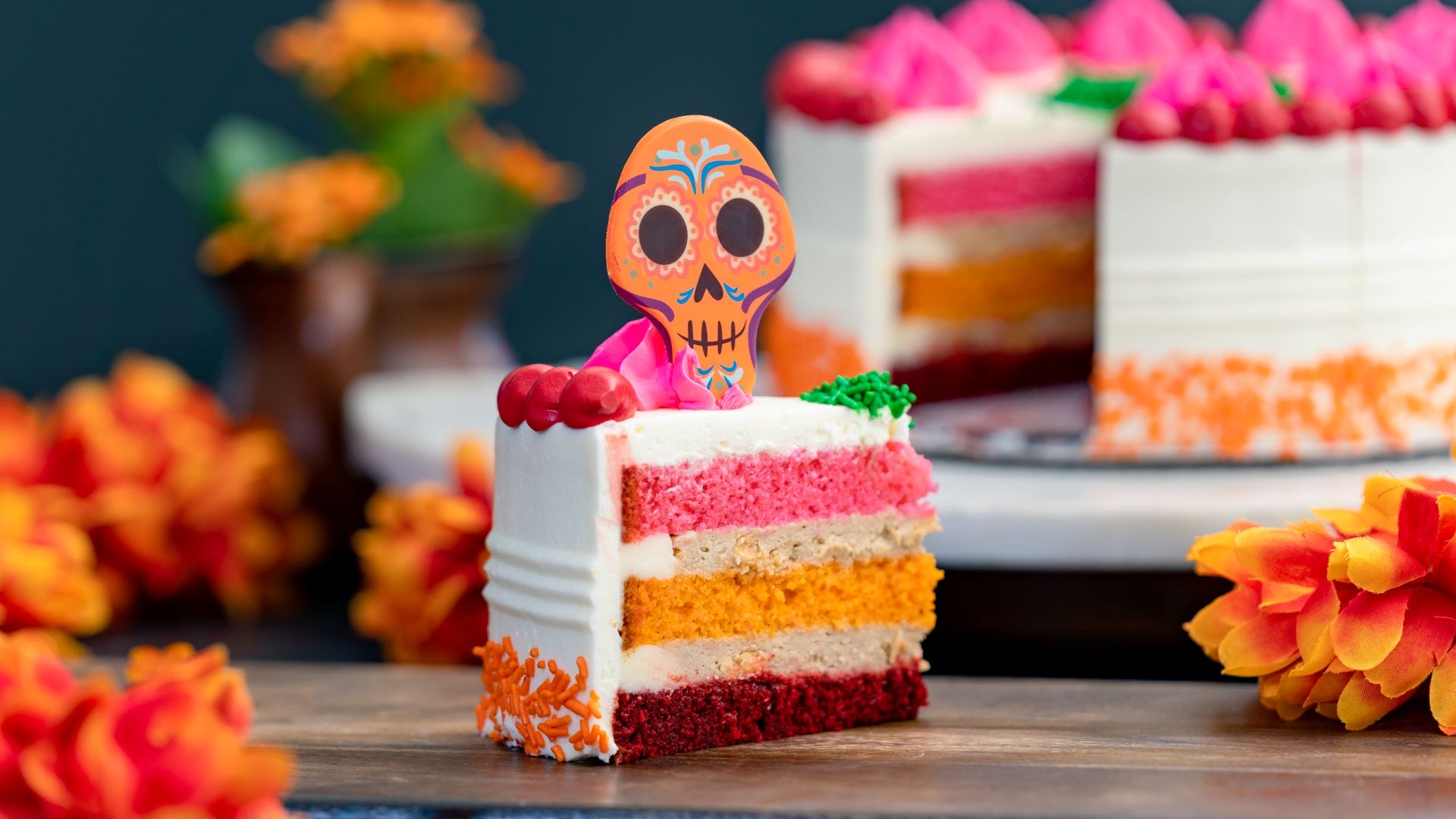 A colorful slice of layered cake with a sugar skull, inspired by Plaza de la Familia at Disney California Adventure.
