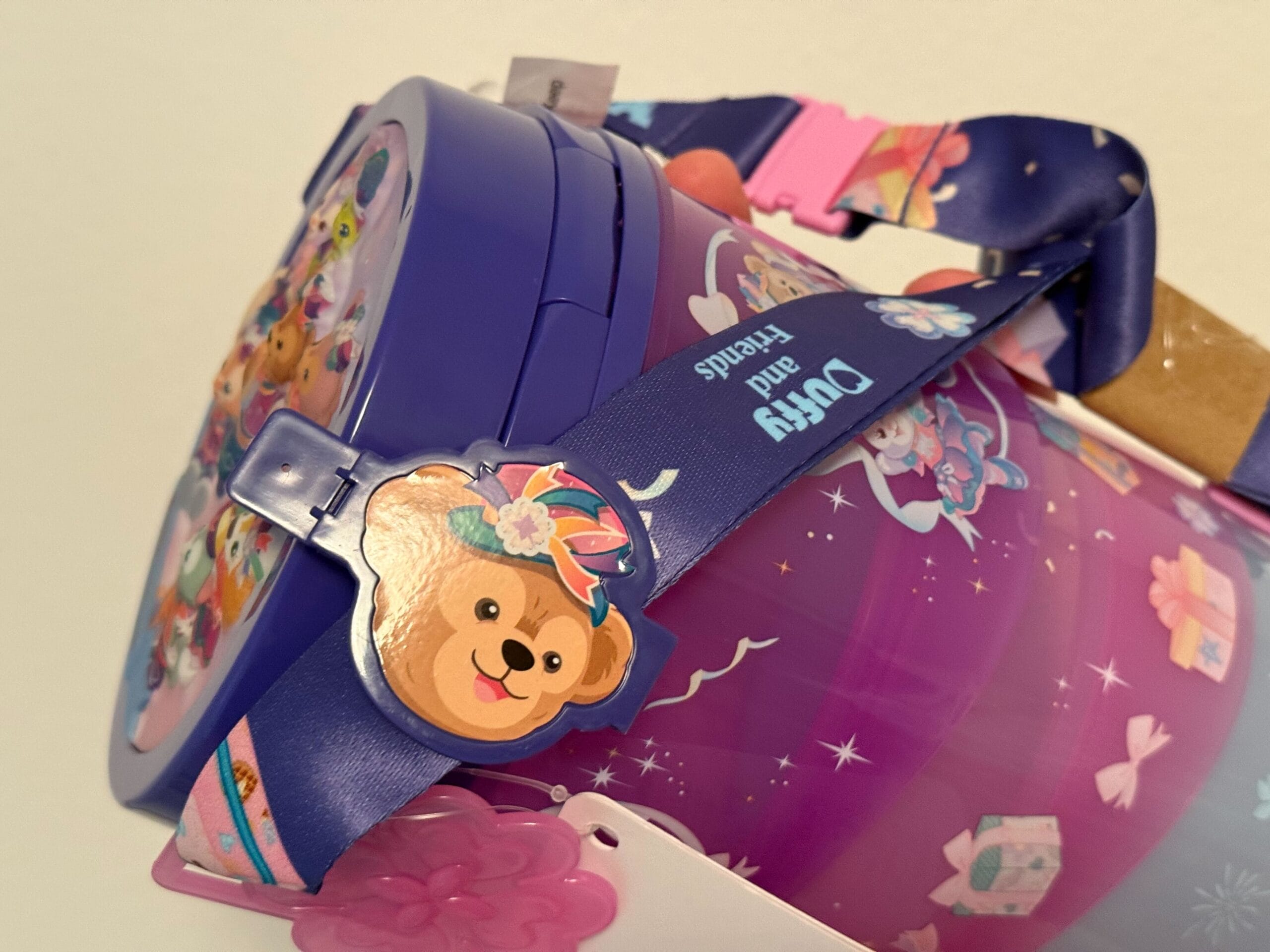 A purple bucket with cartoon bear designs and a matching “Duffy and Friends” strap decorated with flowers.