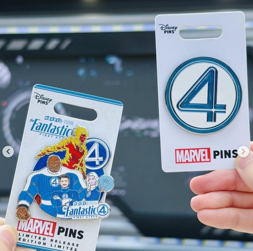 Two hands hold Fantastic Four pins from Hong Kong Disneyland, one with the team and logo, another with just the number 4.