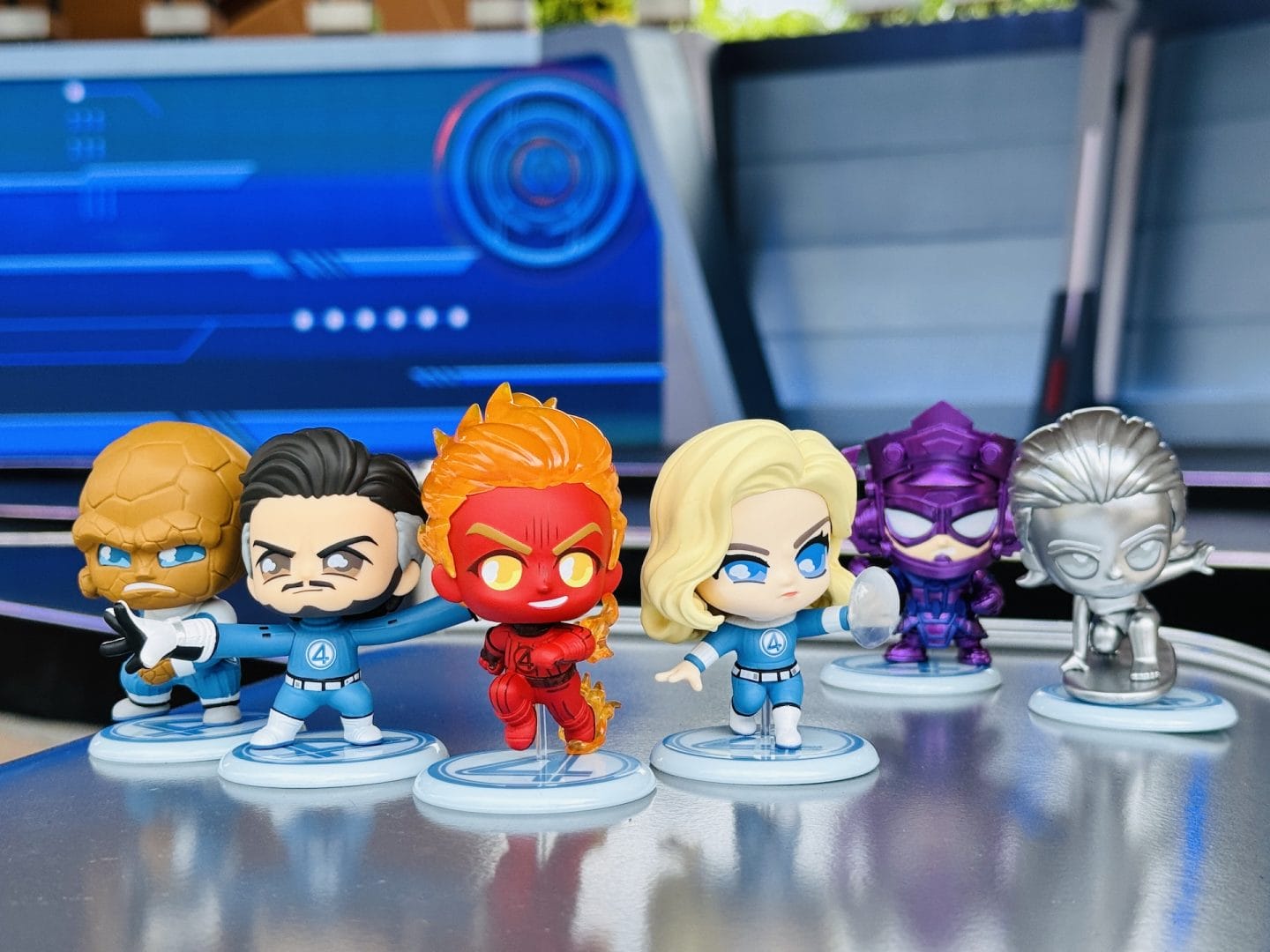 Six stylized superhero figurines, including Fantastic Four, posed on a metallic surface at Hong Kong Disneyland.