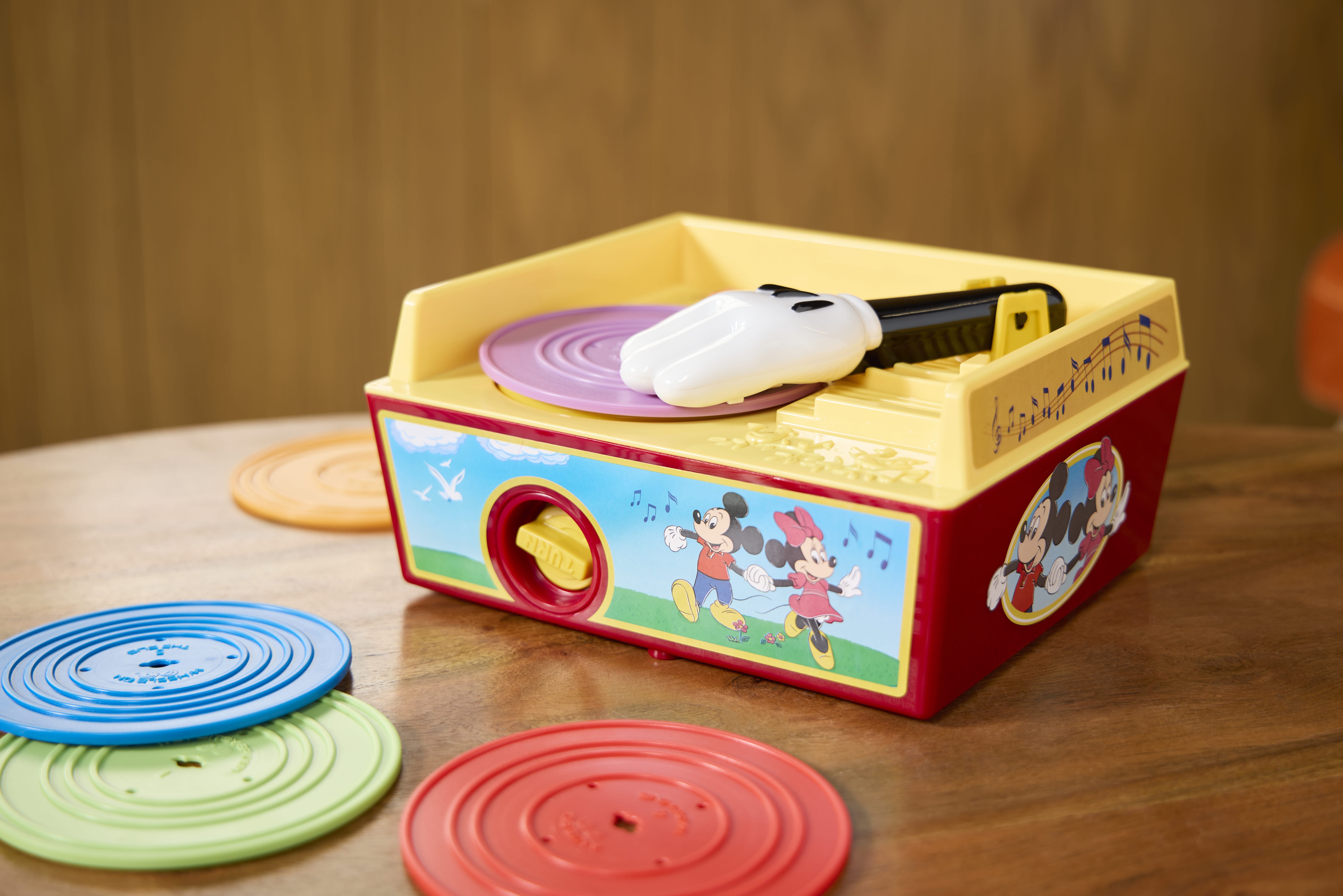 A vintage Disney toy record player with colorful records, perfect for collectors of retro Fisher Price toys.