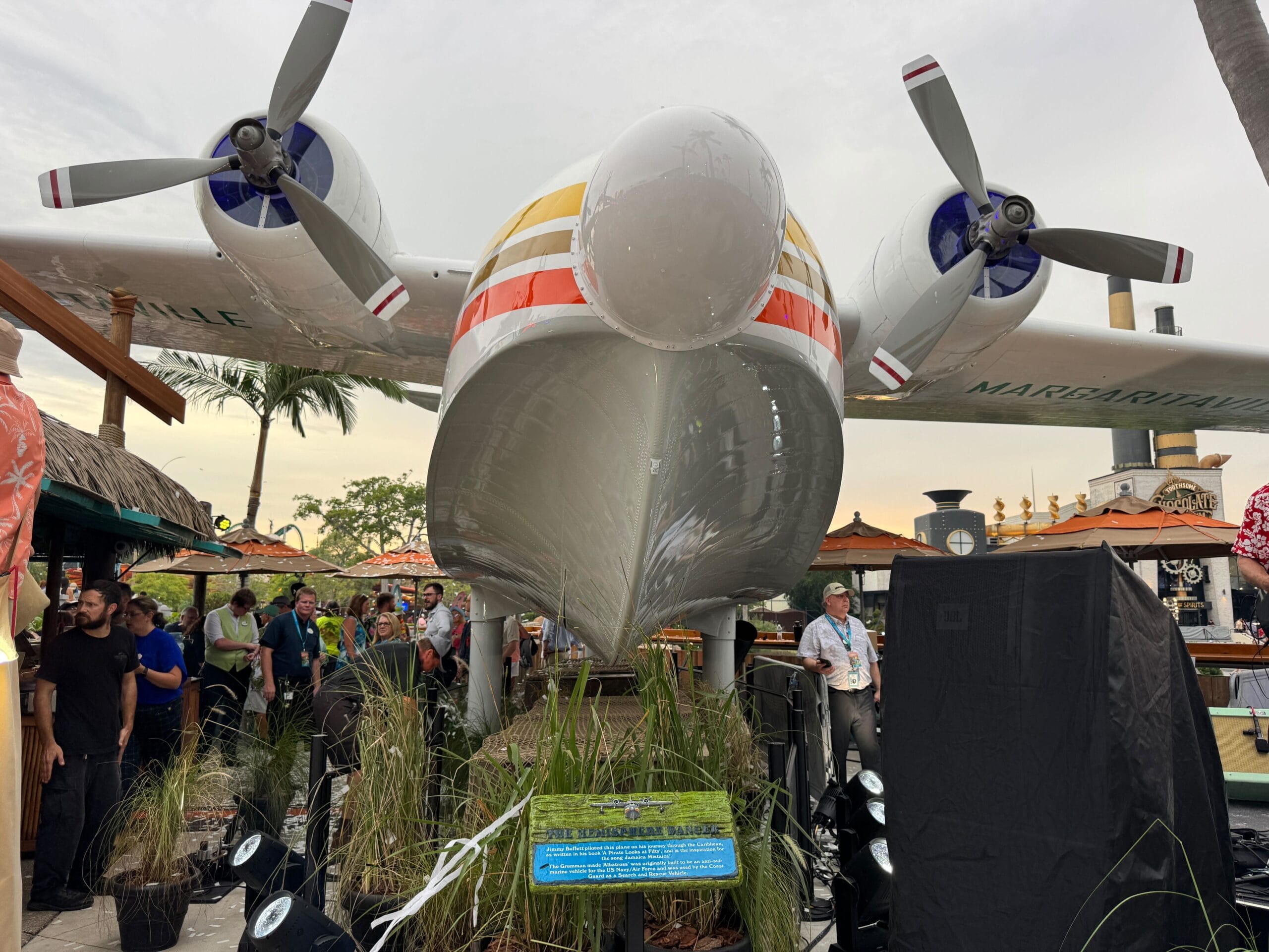 The Hemisphere Dancer seaplane on display at Universal CityWalk, surrounded by tropical plants and event-goers.
