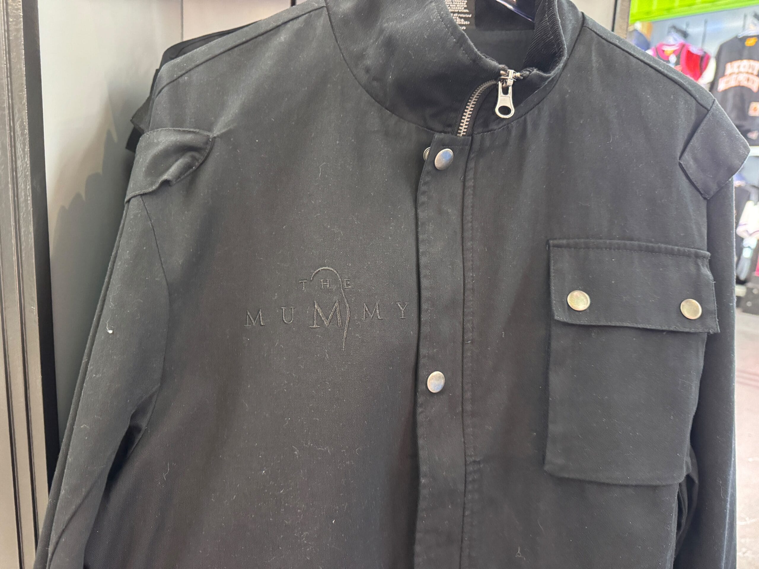 Black jacket from the UNIVRS Mummy Collection featuring "The Mummy" logo subtly embroidered on the chest.