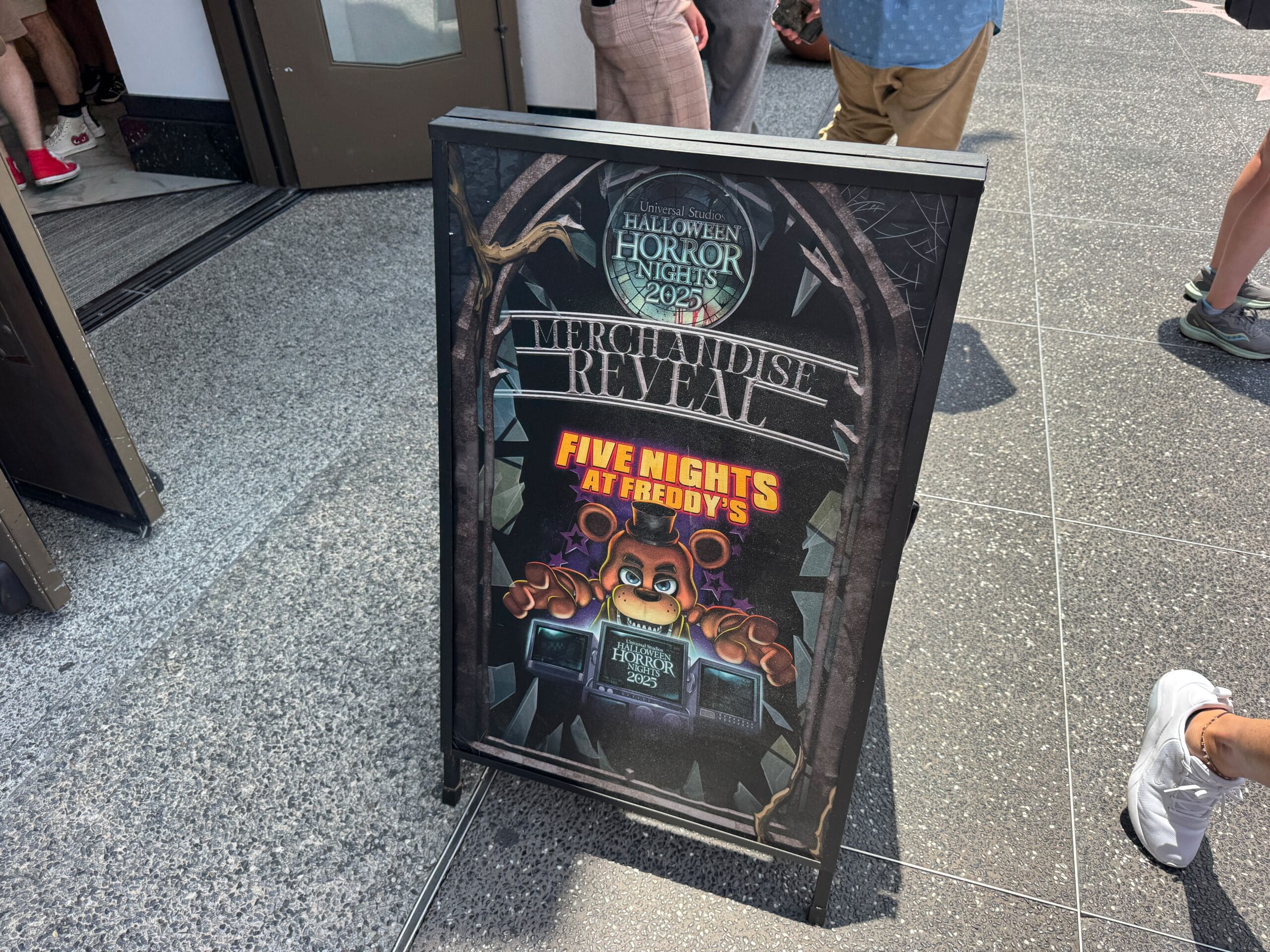 A sign at Universal Studios promotes Halloween Horror Nights 2024 and Five Nights at Freddy's merchandise.