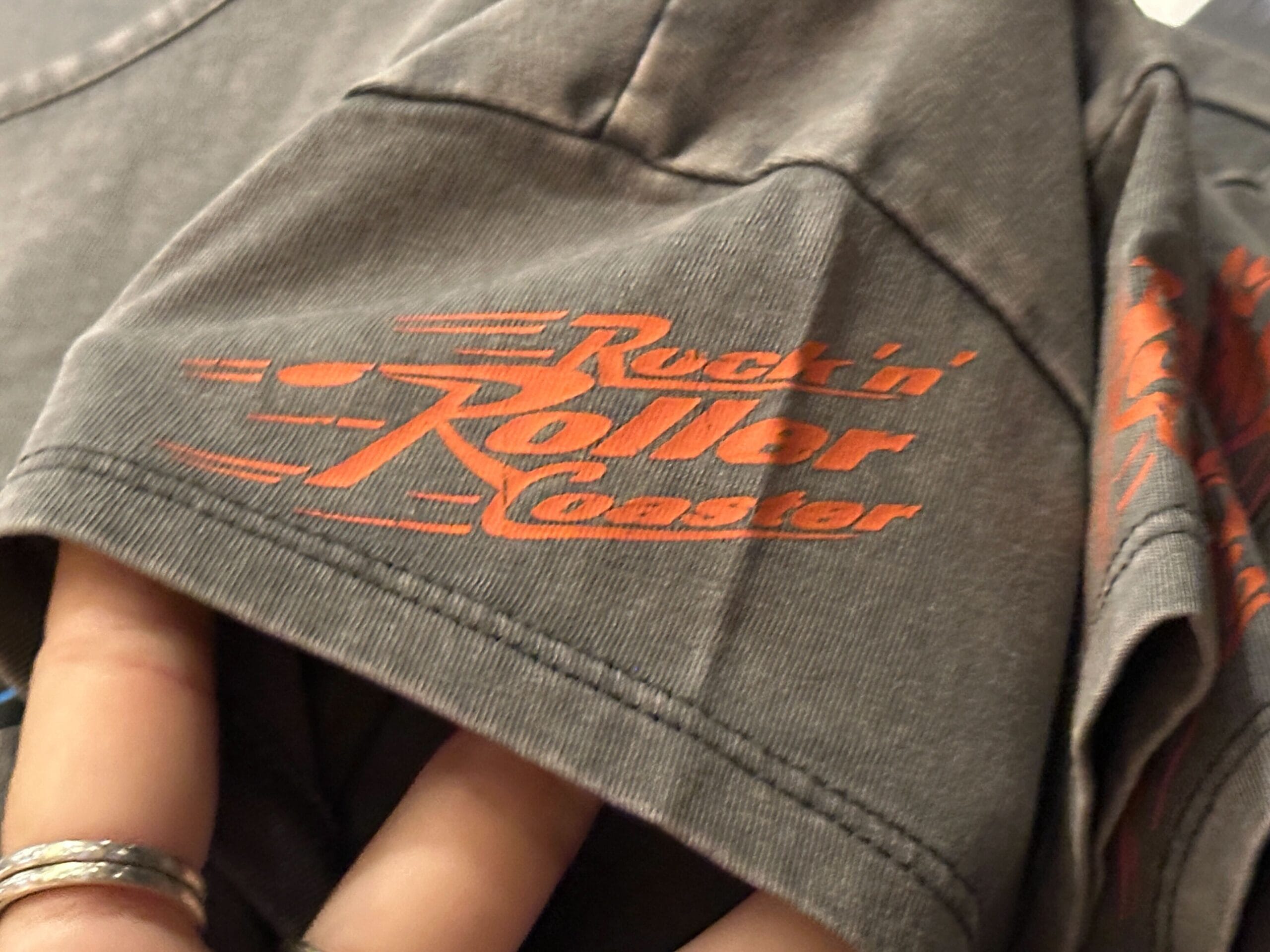 Close-up of a gray shirt sleeve with Rock 'n' Roller Coaster logo and new merch at Disney's Hollywood Studios.